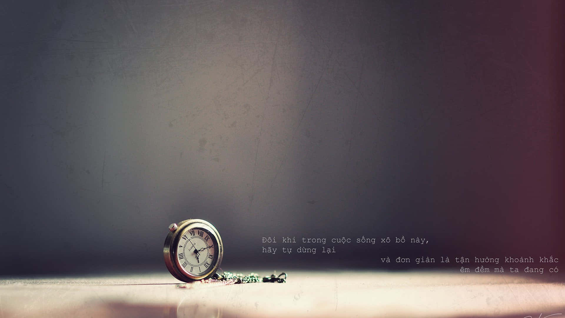 Time 桌布 壁紙 — 一隻復古懷錶獨自放在佈滿灰塵的表面上，背景是帶有越南文字疊加的柔和漸變牆壁。