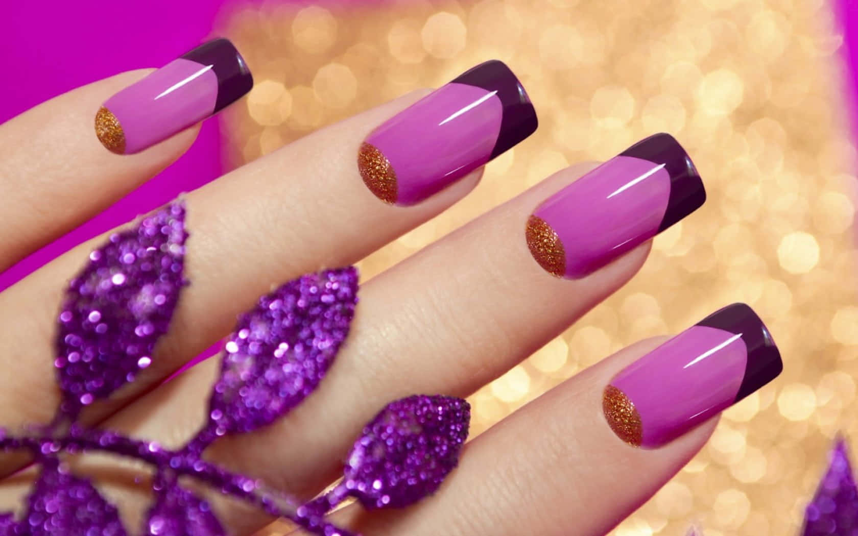Cute Nails 桌布 壁紙 — 一隻手，指甲是紫色和黑色，點綴金色閃粉，背景是閃爍的粉紅和金色散景。