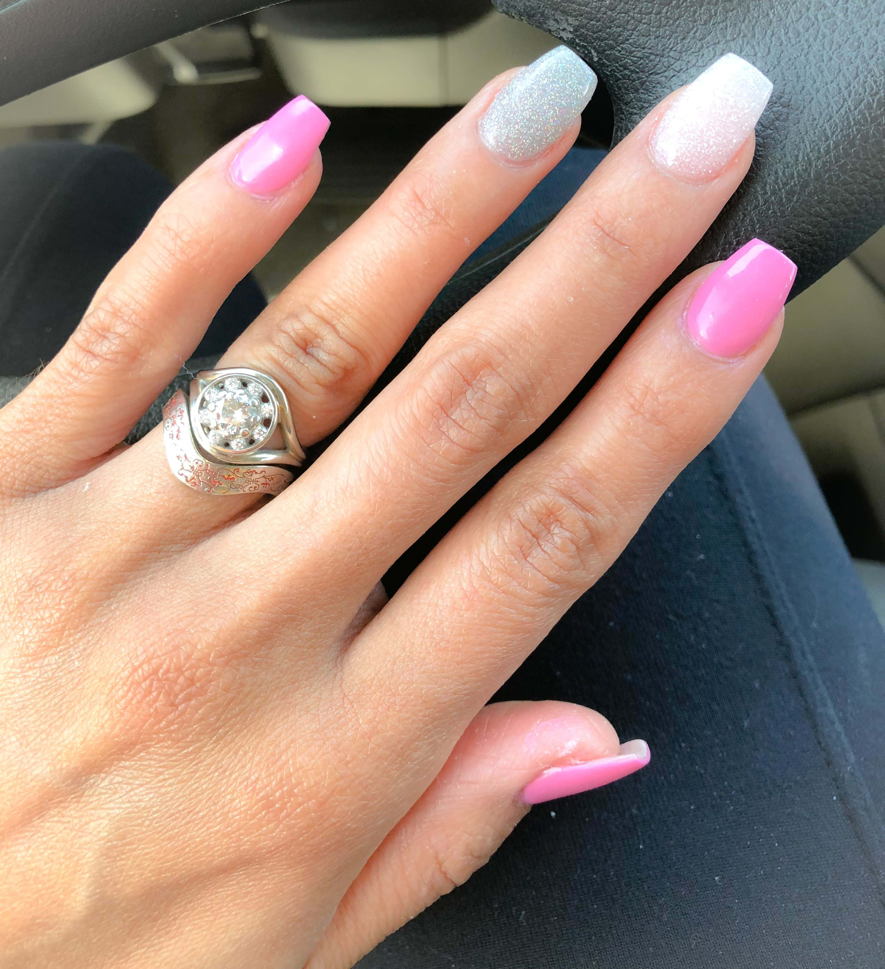 Spring Nails 桌布 壁紙 — 一隻手嘅特寫，有粉紅色同閃銀色指甲同鑽石戒指，放喺汽車軚盤上面。
