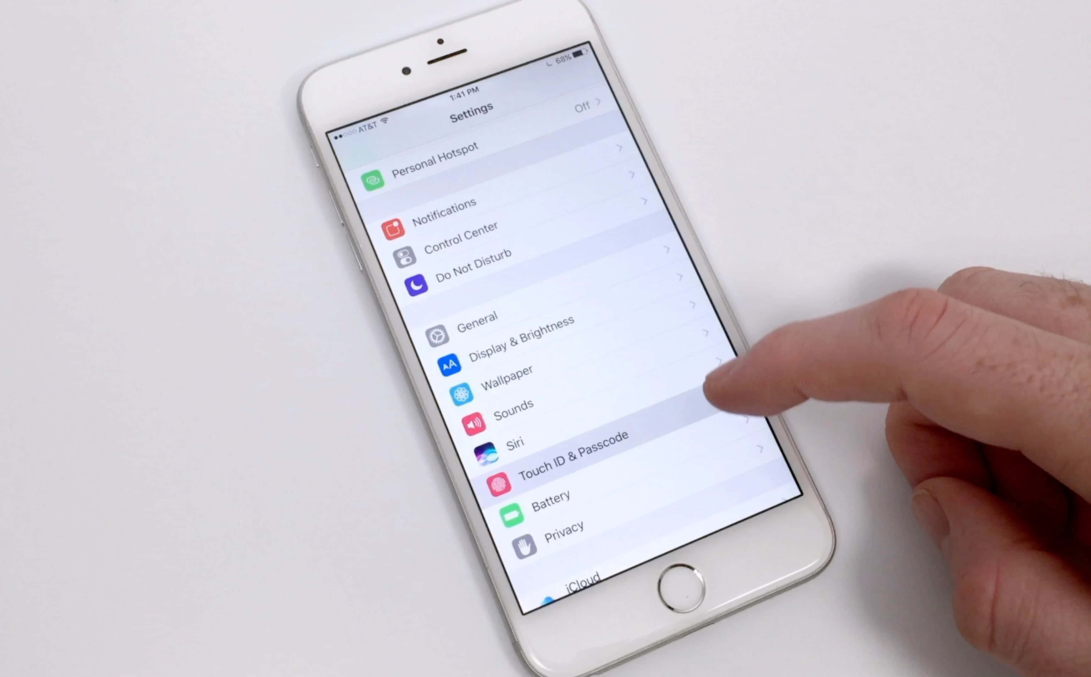 Touch Id 桌布 壁紙 — 一隻手在純白色背景的iPhone設定畫面上點擊牆紙選項。
