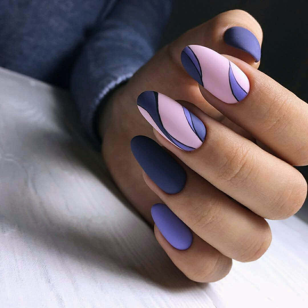 Spring Nails 桌布 壁紙 — 一隻手帶有啞光紫色和粉紅色抽象波浪指甲藝術，放在白色表面上。