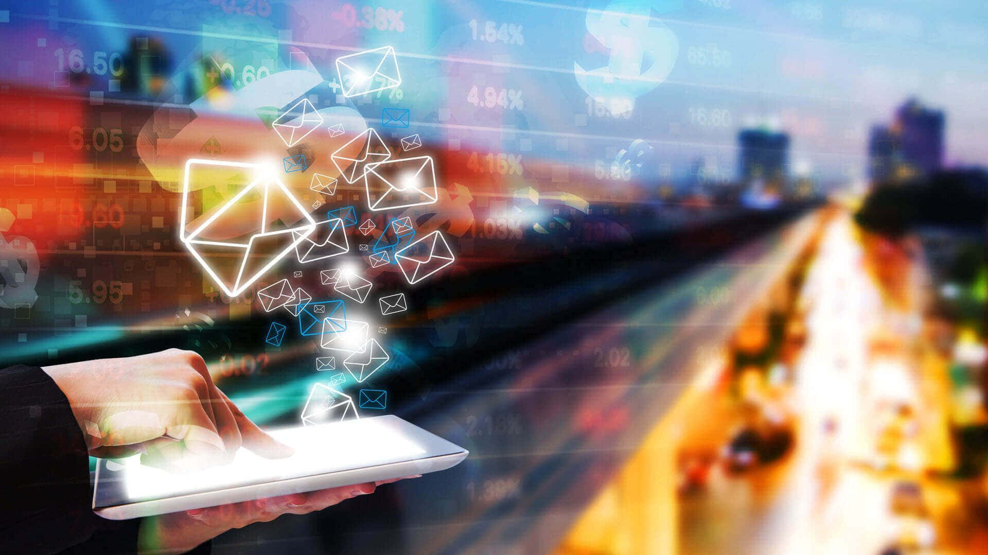 Email 桌布 壁紙 — 一隻手拿著發光的平板電腦，數位郵件圖標和財務數據在黃昏時分模糊的城市景觀上方漂浮。