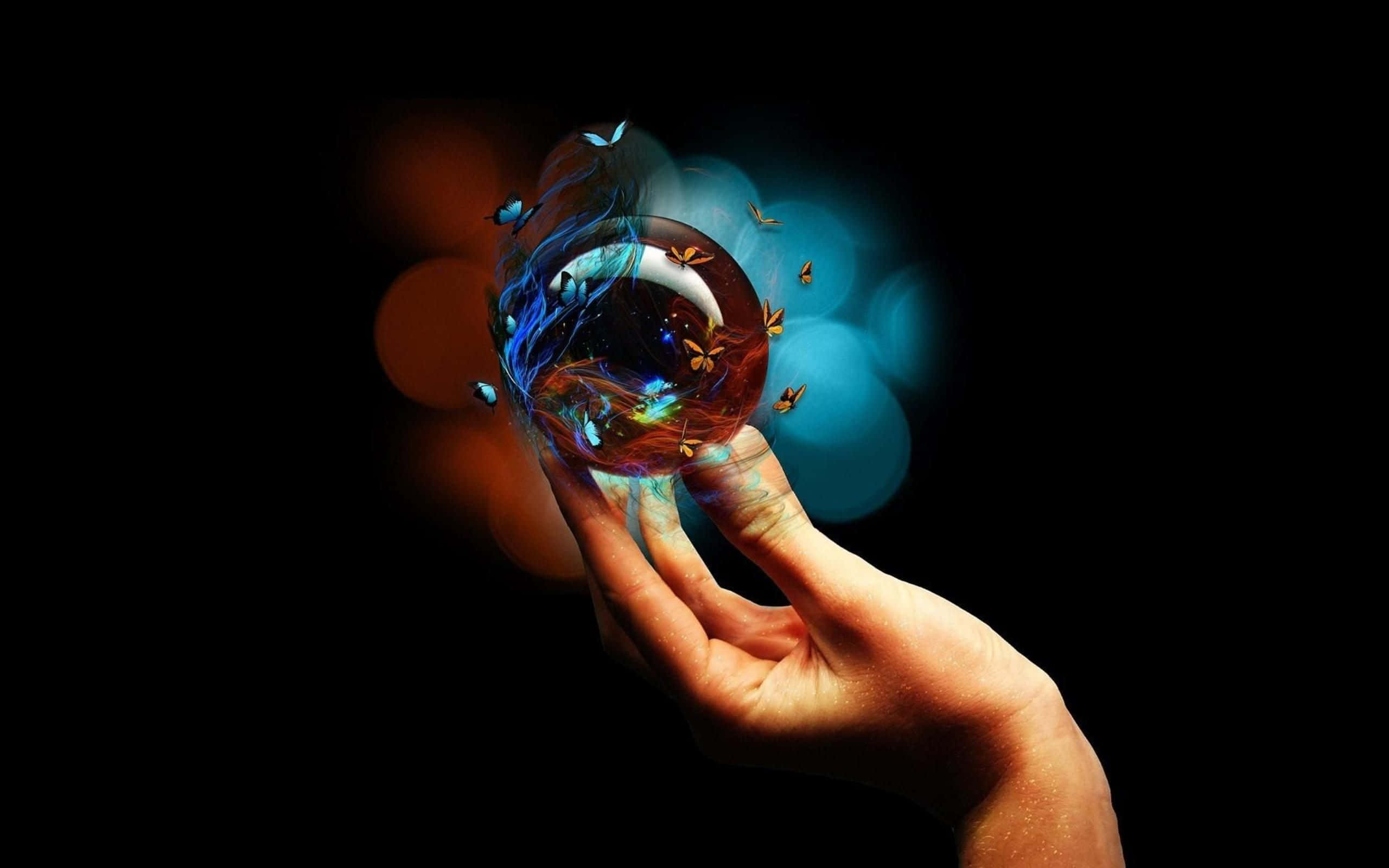 Crystal Ball 桌布 壁紙 — 一隻手捧著一個發光的球體，球體中旋轉著蝴蝶和宇宙光芒，背景是暗色散景。