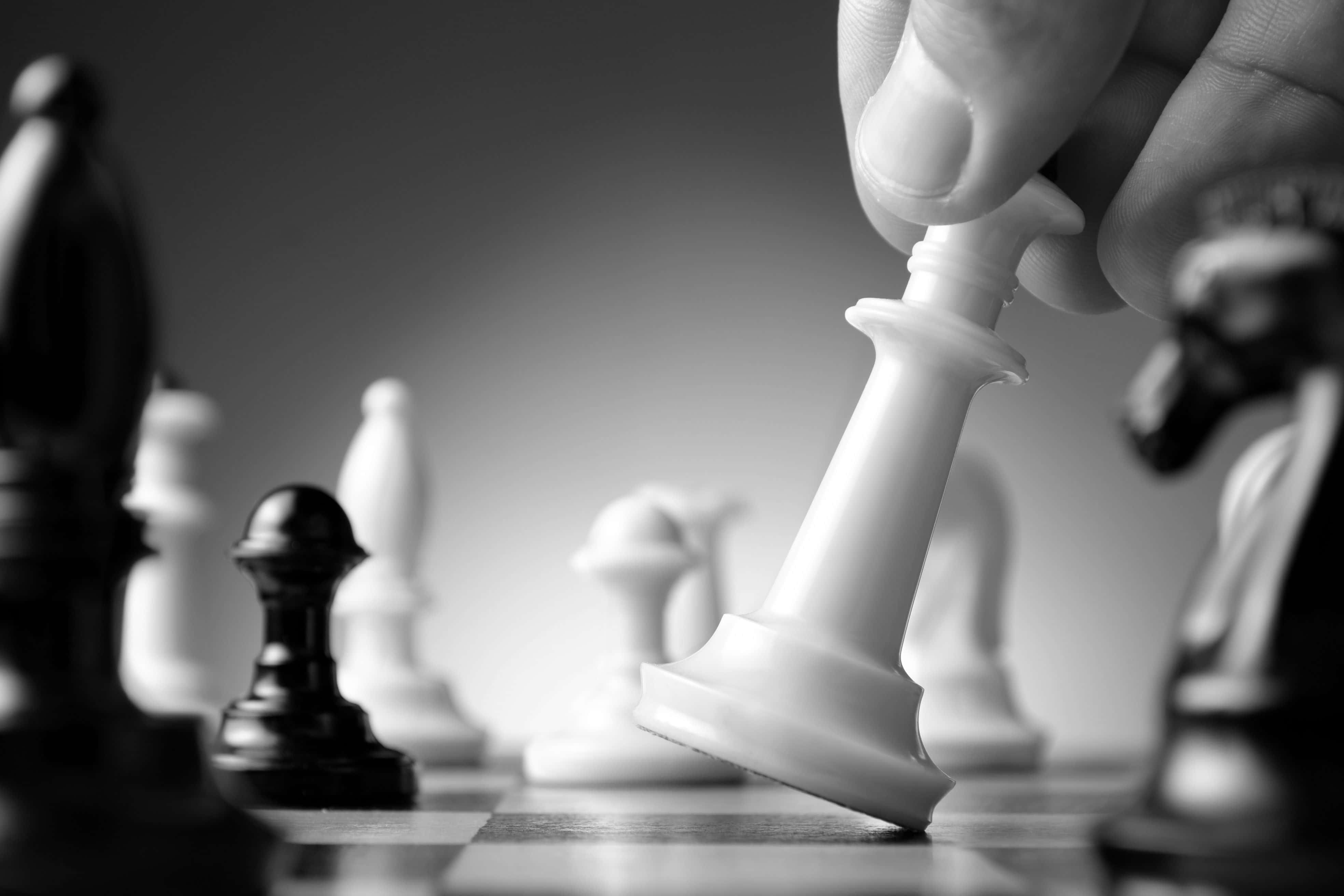 一隻手正在將一枚棋子放在棋盤上 壁紙