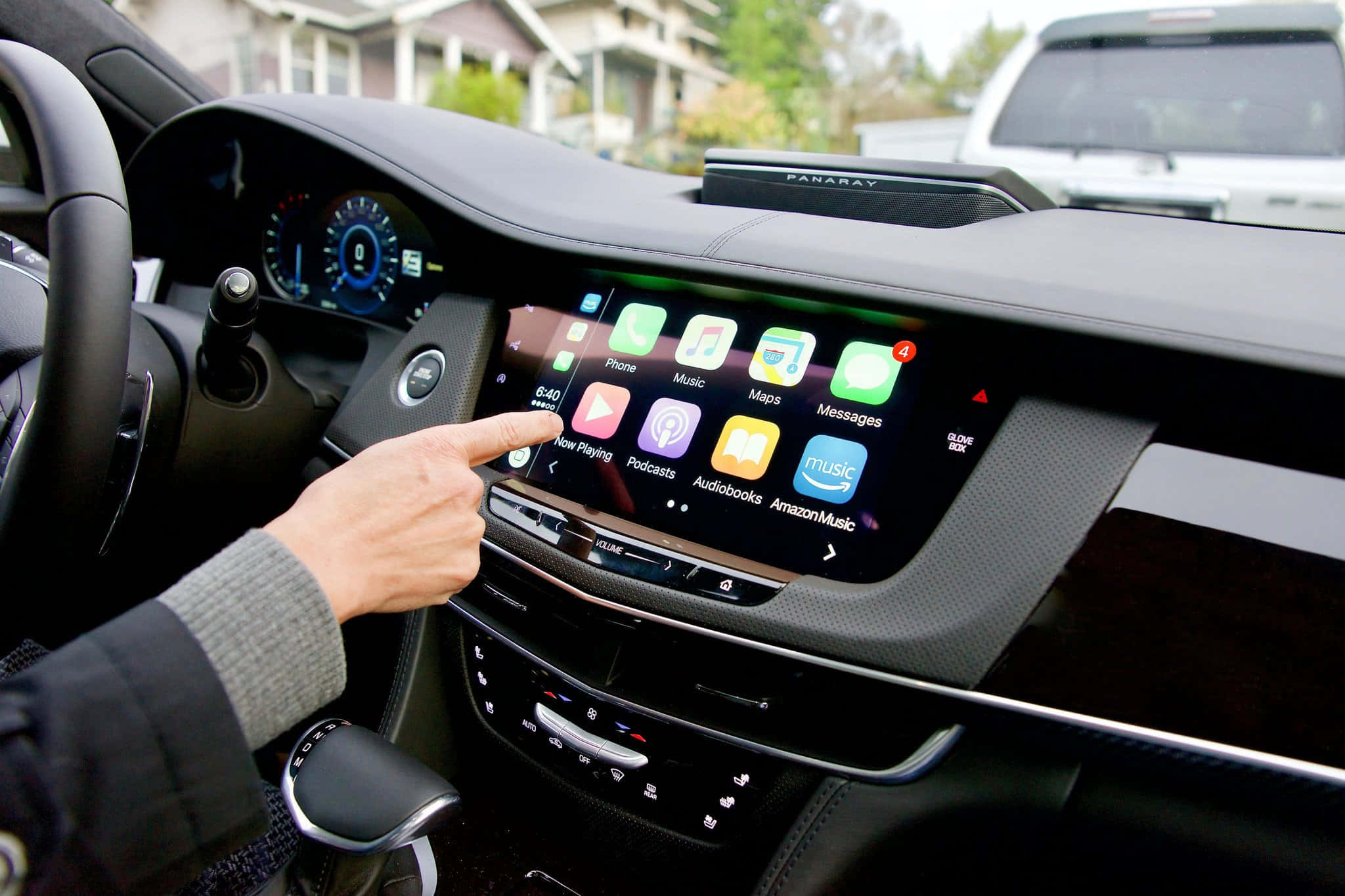 Car Technology 桌布 壁紙 — 一隻手點擊現代汽車儀表板上的大型觸控螢幕，顯示色彩繽紛的應用程式圖標。