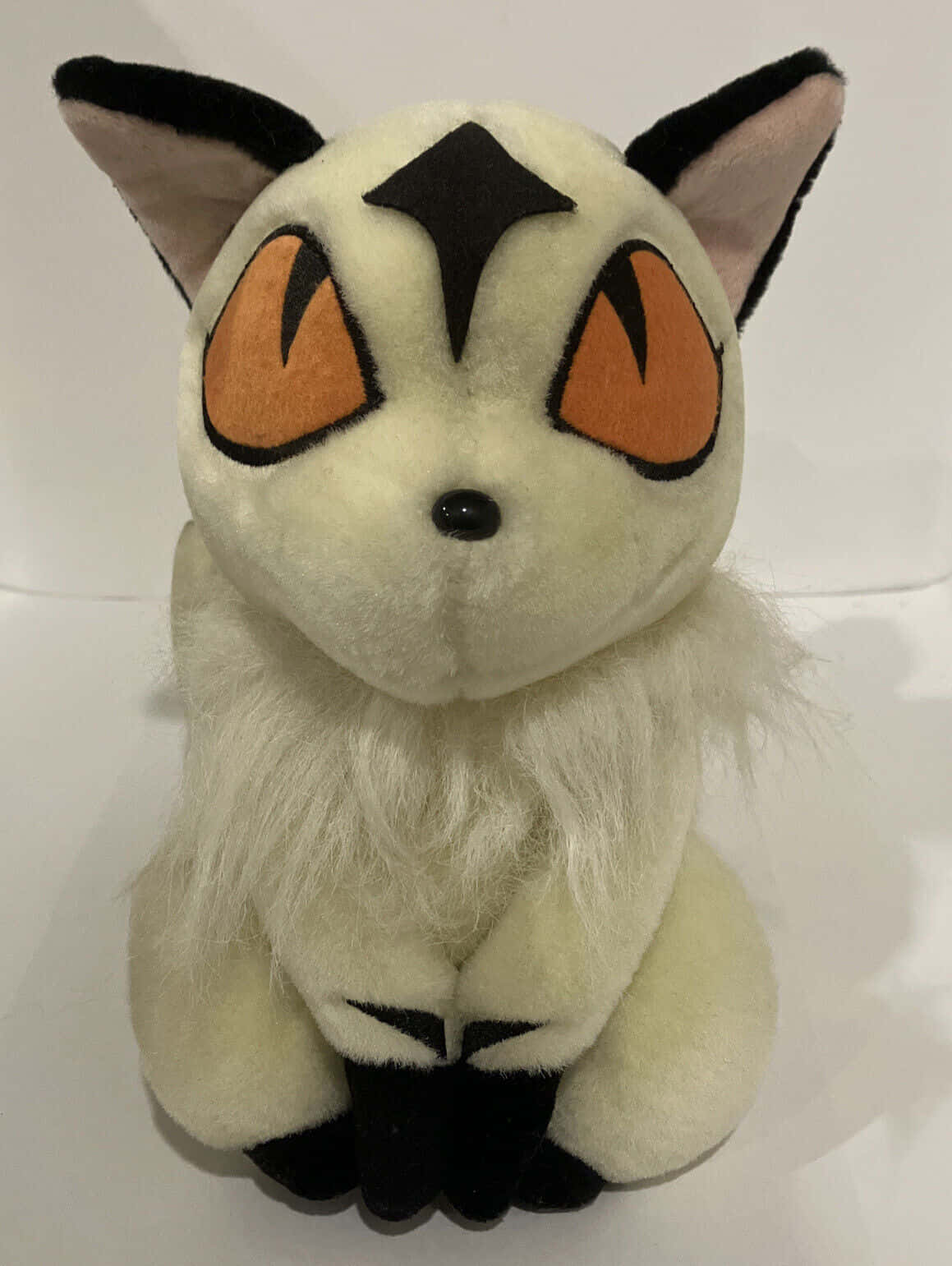 Inuyasha Nekomata 桌布 壁紙 — 一隻擁有奶油色毛髮、黑色斑紋和橙色大眼睛的 Pokémon 太陽伊布毛絨玩具，直立在純白色背景前。