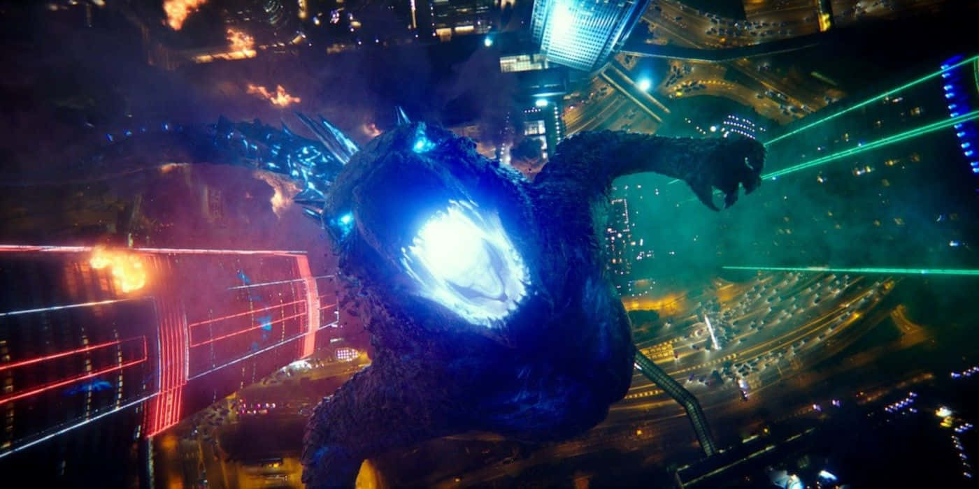 Godzilla Vs Kong 桌布 壁紙 — 一隻擁有發光眼睛的龐大怪物主宰著夜晚燃燒的城市景觀，從爪子發射綠色激光。