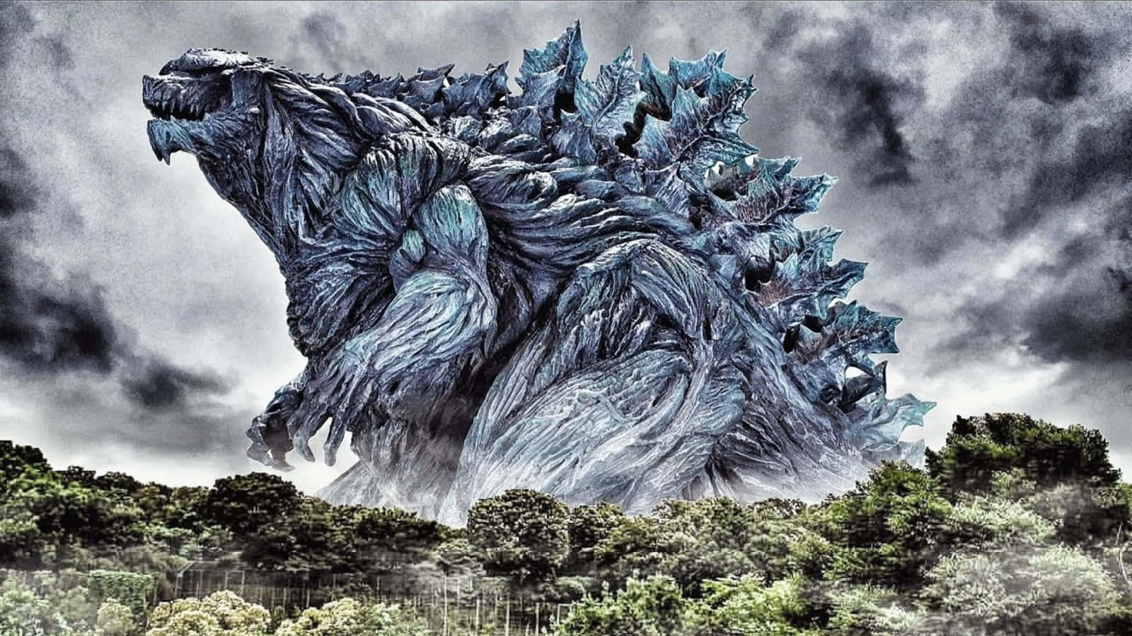 Godzilla Earth 桌布 壁紙 — 一隻擁有鋸齒狀藍灰色鱗片的巨大哥斯拉在暴風雨的天空下在森林上方咆哮。