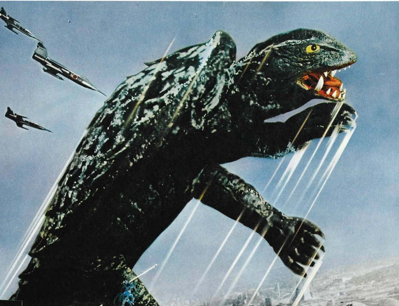 Gamera 桌布 壁紙 — 一隻擁有黃色眼睛的巨型黑色怪物在咆哮，而戰鬥機在陰雲密佈的天空中向其發射導彈。