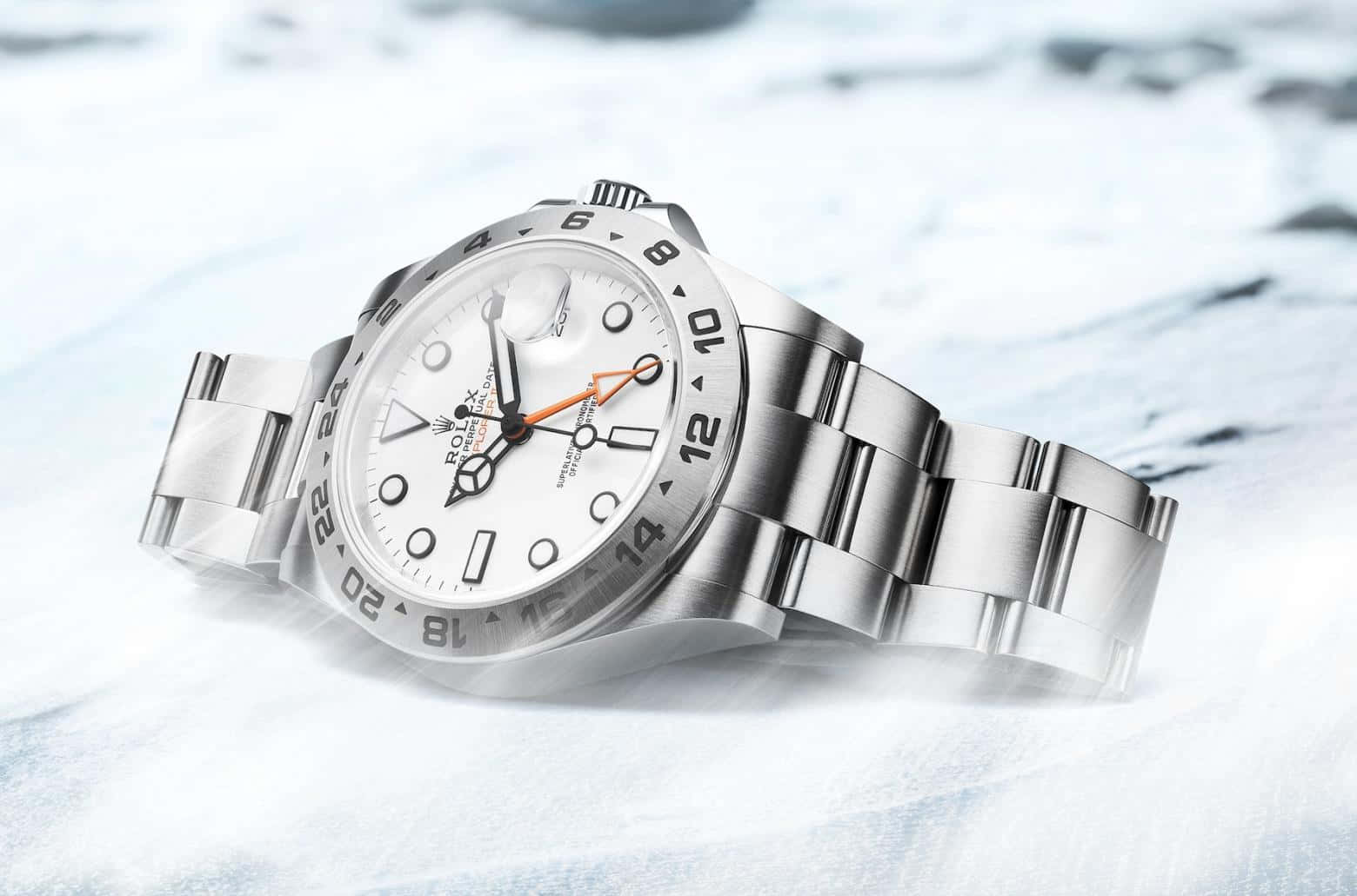 Rolex 桌布 壁紙 — 一隻時尚的銀色勞力士手錶放在雪白和藍色調的雪地上。
