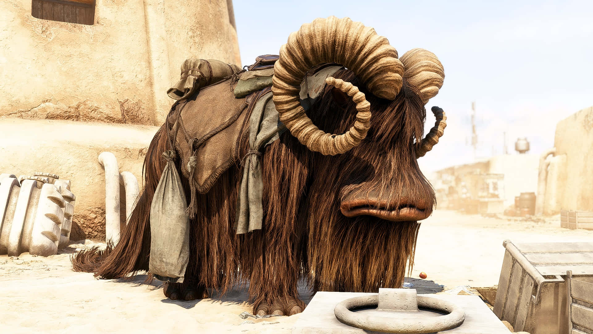 Bantha 桌布 壁紙 — 一隻毛茸茸、長著巨大彎角的大公羊，在明亮的日光下，背著鞍具站在塵土飛揚的沙漠小鎮中。