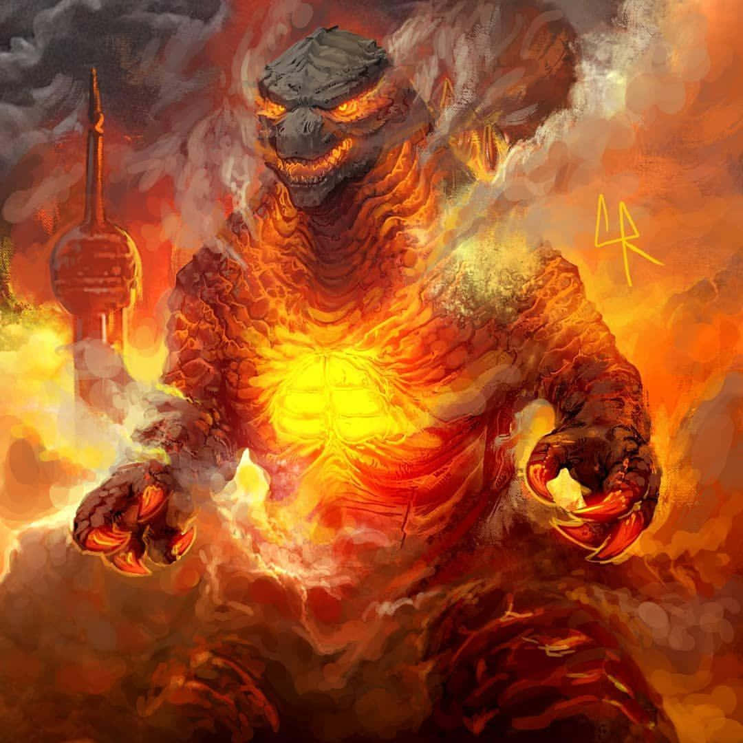 Burning Godzilla 桌布 壁紙 — 一隻火熱的哥斯拉在煙霧和火焰中咆哮，身後有一座城市塔樓正在燃燒。