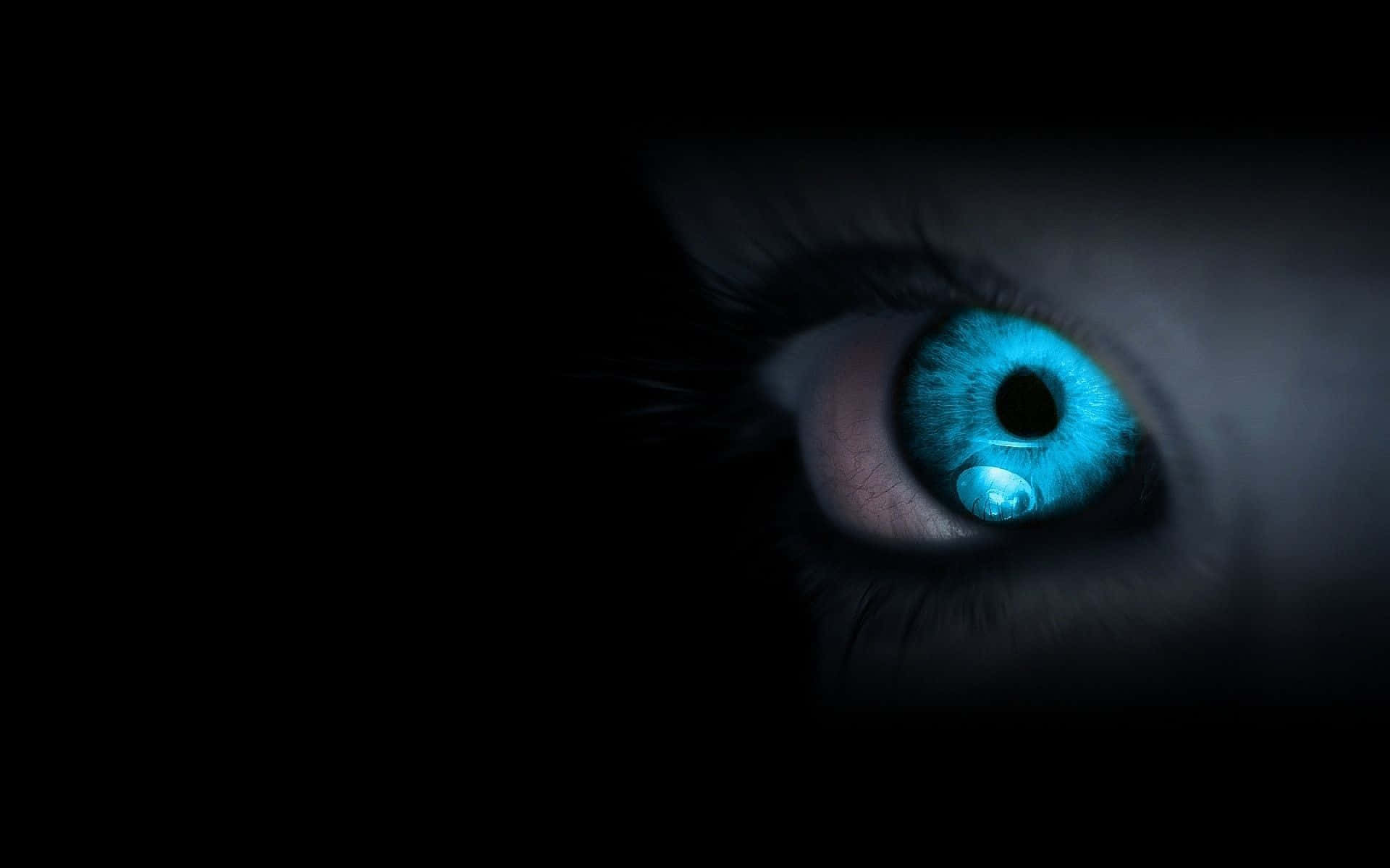 Eyes 桌布 壁紙 — 一隻發光的藍色眼睛帶著一滴淚珠，在漆黑的背景下強烈地凝視著。