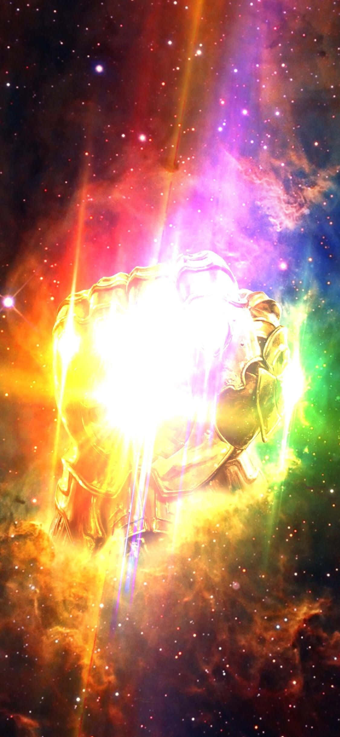 Mind Stone 桌布 壁紙 — 一隻發光的金色手套散發出強烈的光芒，映襯著充滿星星和彩色氣體雲的充滿活力的宇宙星雲。