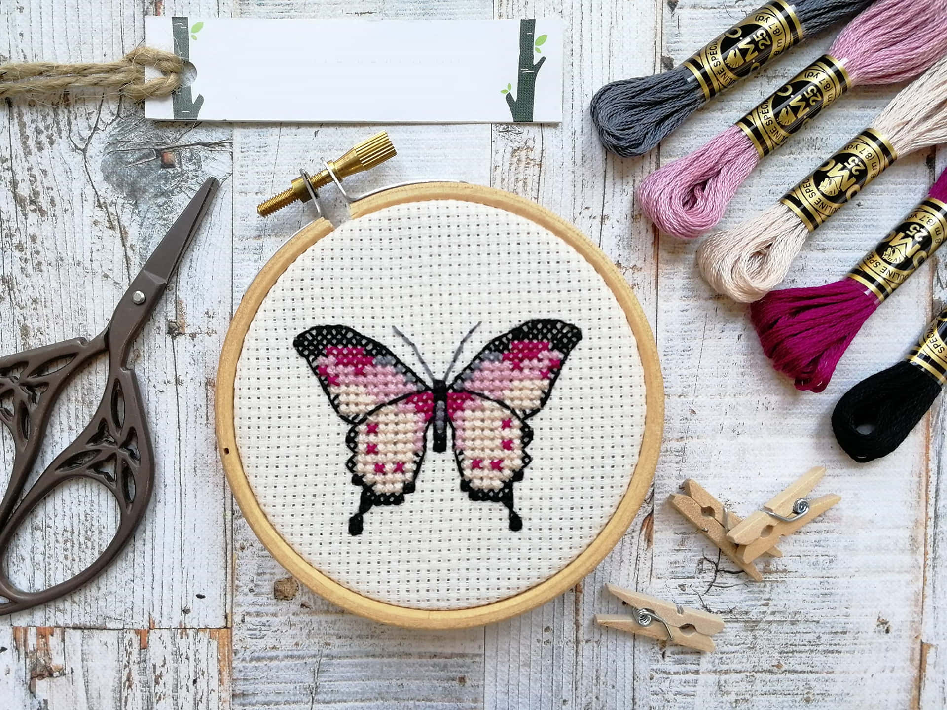 刺繡框內有繡花蝴蝶，周圍有木頭上的手工藝用品。 — 唯美蝴蝶動圖 壁紙