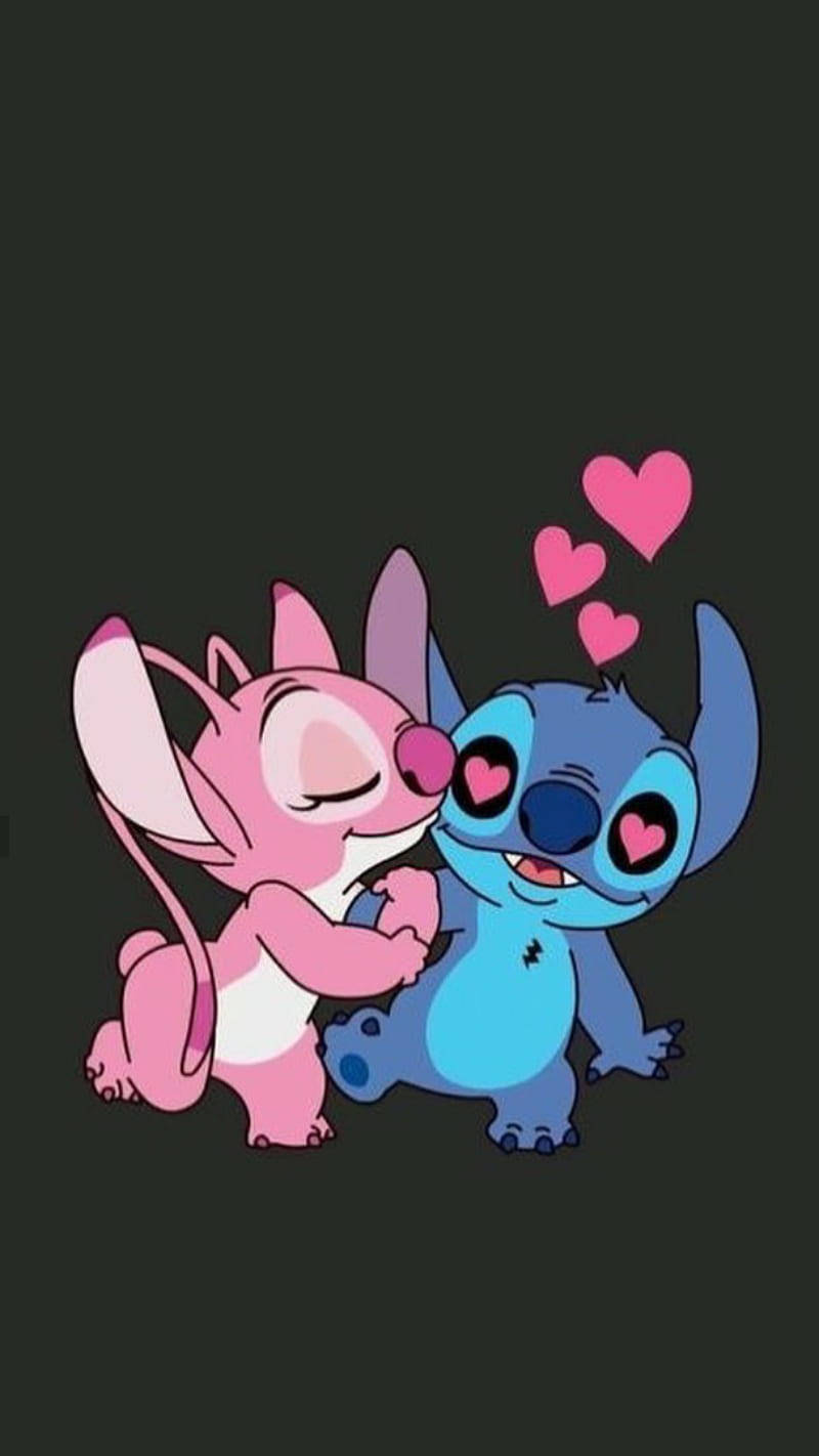 Stitch And Angel 桌布 壁紙 — 一隻粉紅色老鼠同一個藍色外星人喺黑暗背景上分享一個甜蜜嘅吻，周圍有漂浮嘅心形。