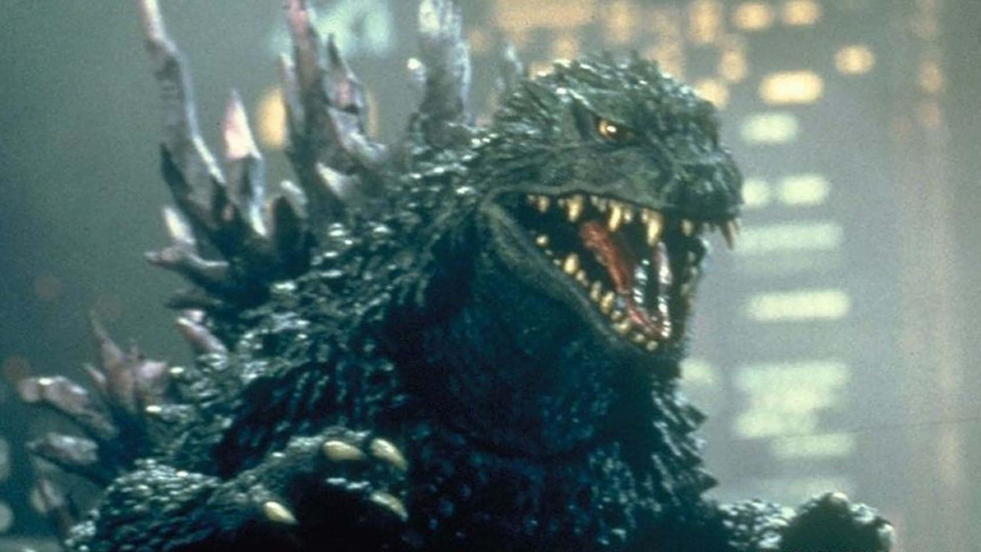 Godzilla 2000 桌布 壁紙 — 一隻背上有刺、眼睛發光的怪獸哥斯拉在夜晚煙霧瀰漫的城市景觀中咆哮。