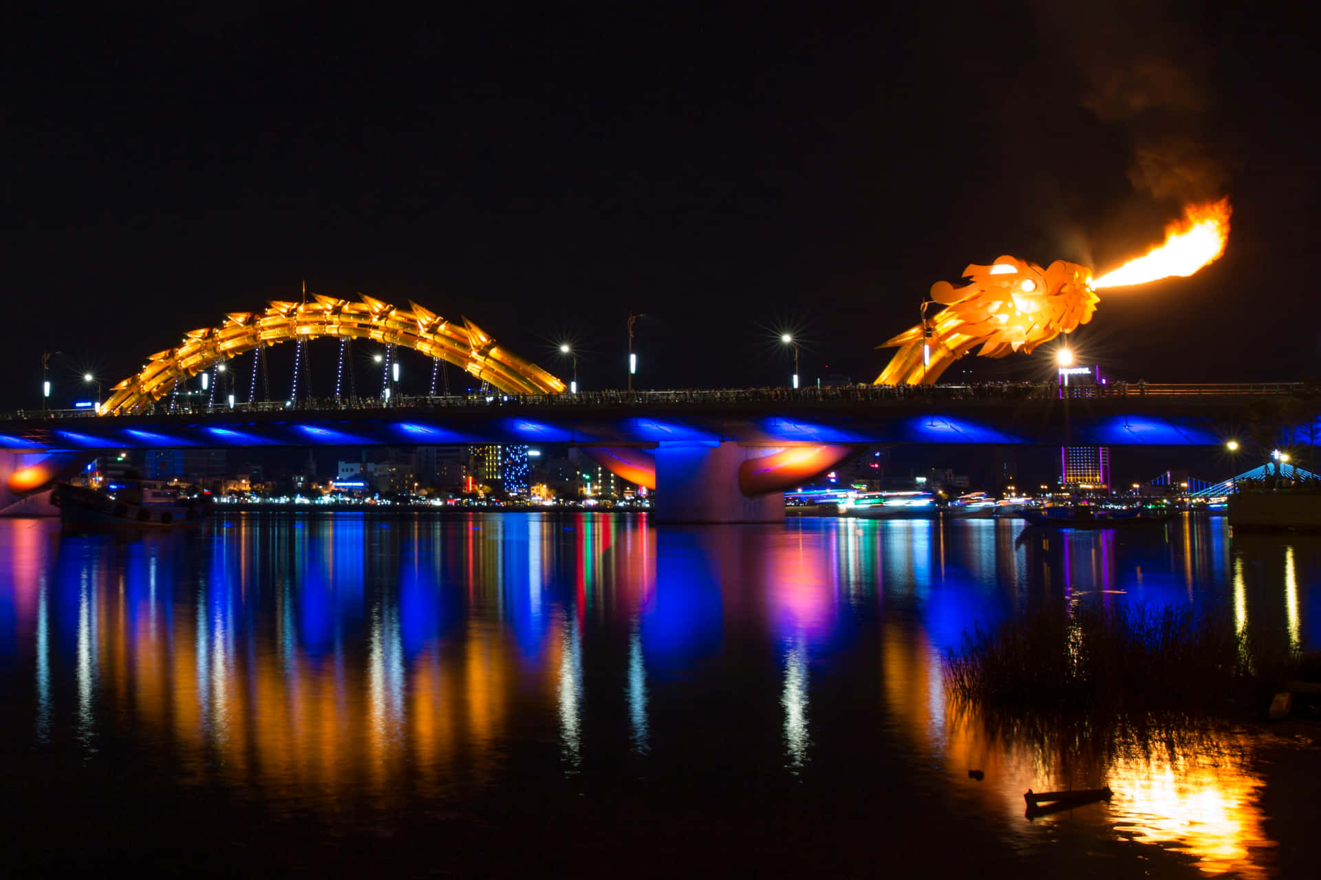 夜間火龍橋，噴火與水中城市倒影。