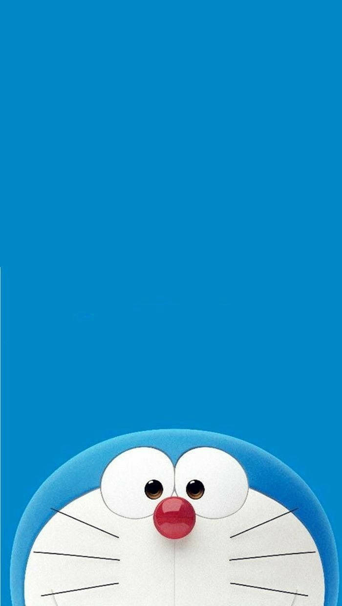 Doraemon 3d 桌布 壁紙 — 一隻開心的藍色機械貓從底部探出頭來，背景是純藍色。