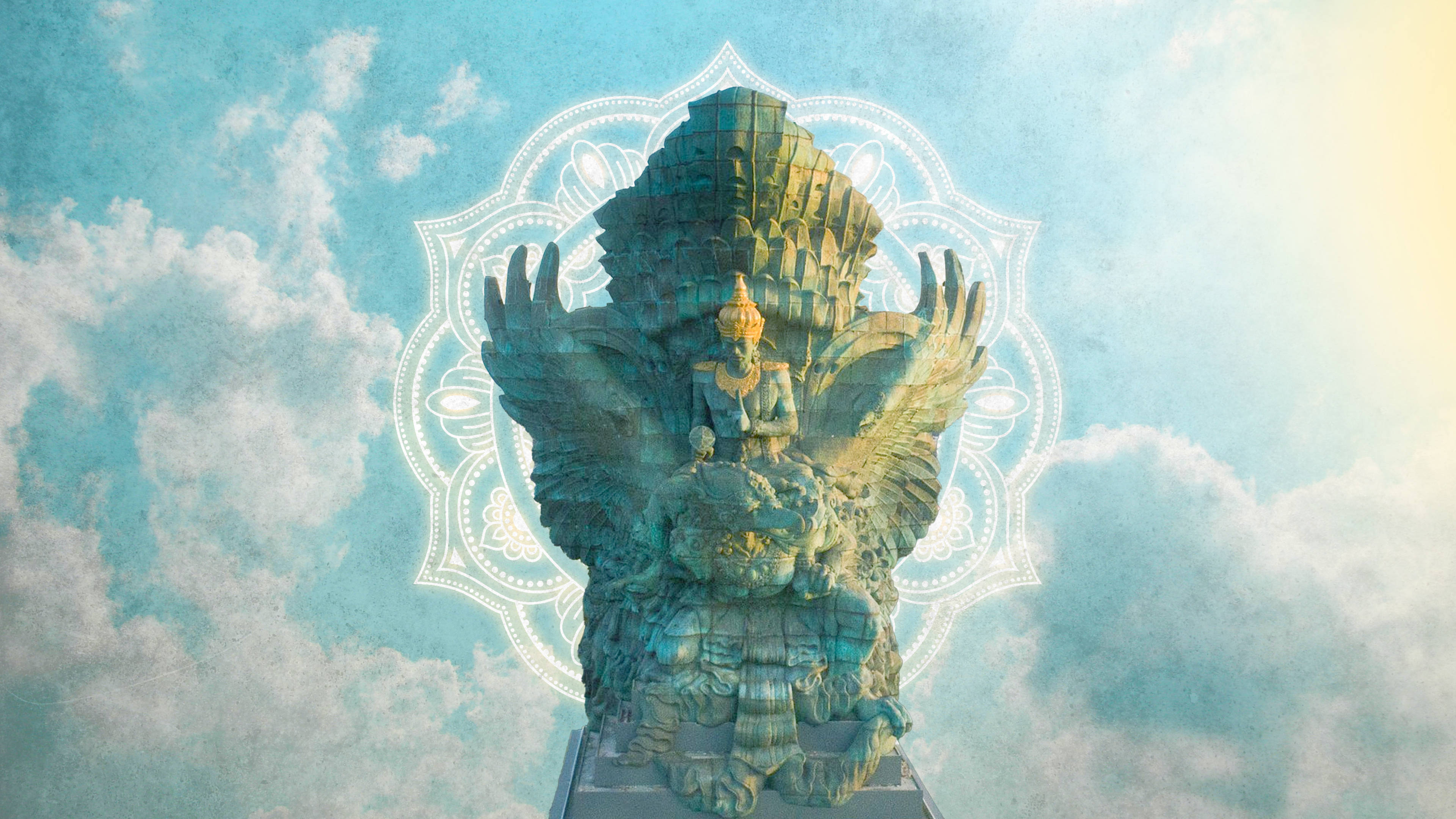 Hindu Temple 桌布 壁紙 — 一隻雄偉的綠松石色迦樓羅雕像展開翅膀，坐在基座上，背景是柔和的藍天、蓬鬆的雲朵和發光的曼陀羅光環。