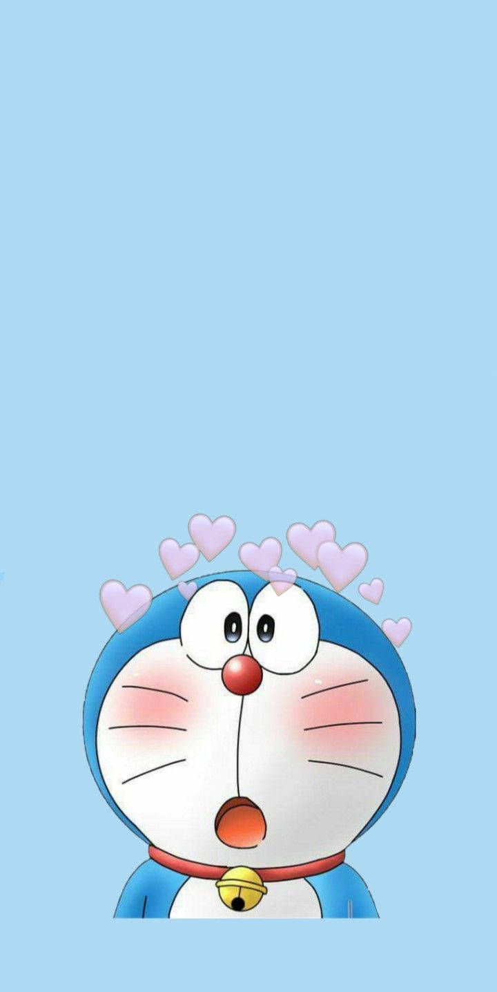 Doraemon 桌布 壁紙 — 一隻驚訝的藍色機械貓，頭頂上有粉紅色心形漂浮在淺藍色背景上。