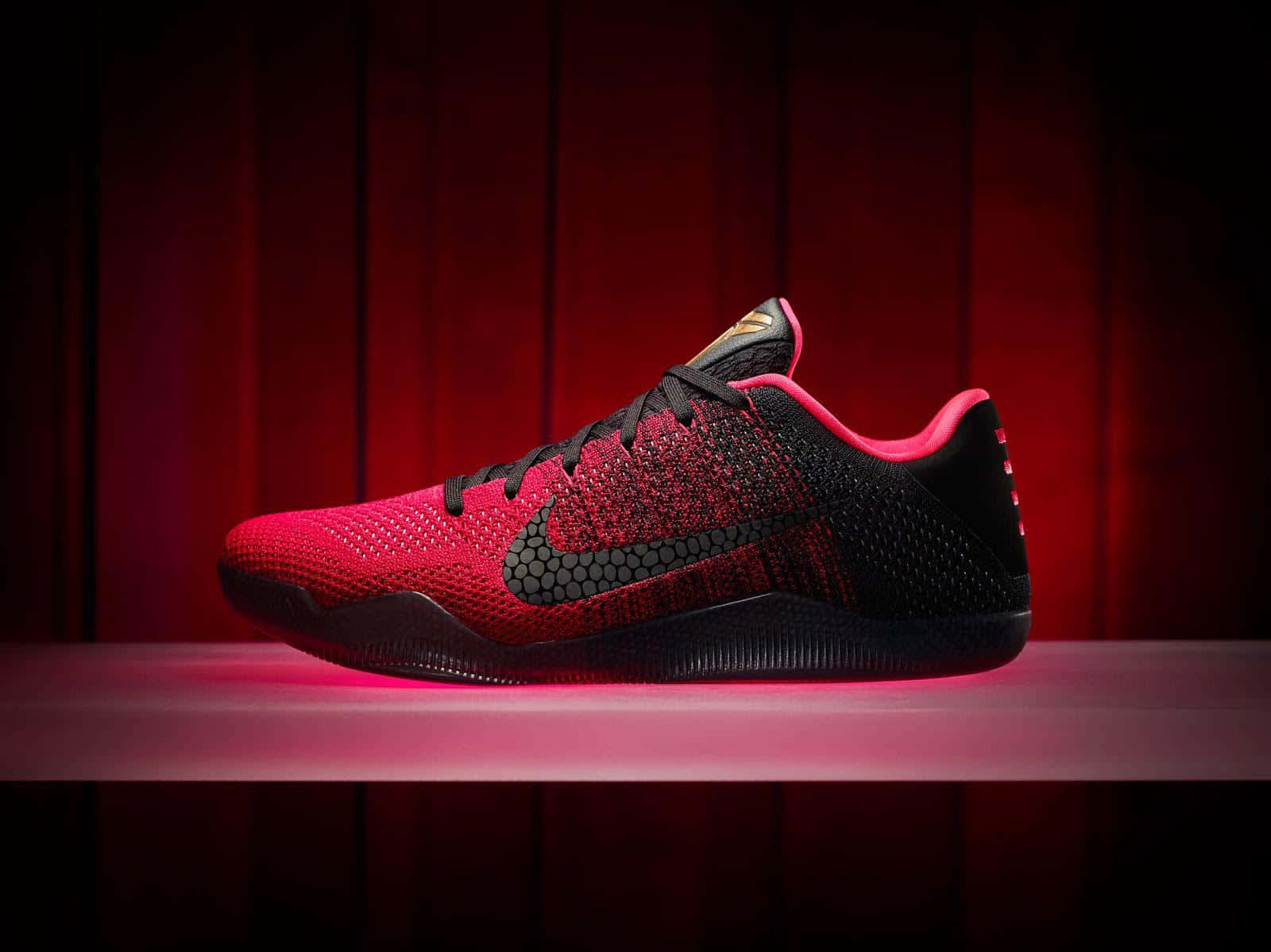 Red Shoes 桌布 壁紙 — 一雙紅黑配色的Nike Kobe運動鞋在深色木質背景下，於戲劇性的粉紅燈光中閃耀。