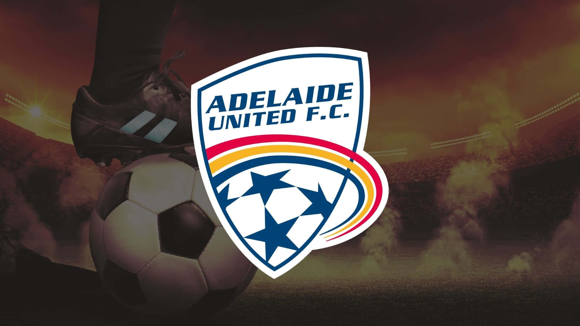 Adelaide United 桌布 壁紙 — 一雙足球靴準備踢球，阿德萊德聯足球會標誌在球場背景下突出顯示。