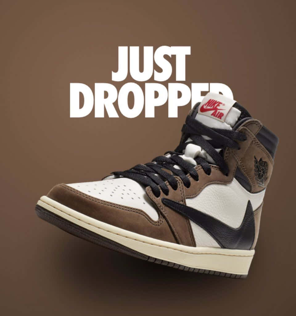 Travis Scott Jordan 1 桌布 壁紙 — 一雙高筒Nike Air Jordan運動鞋，棕色、白色和黑色，漂浮在純棕色背景上，帶有粗體白色文字寫著「just dropped」。