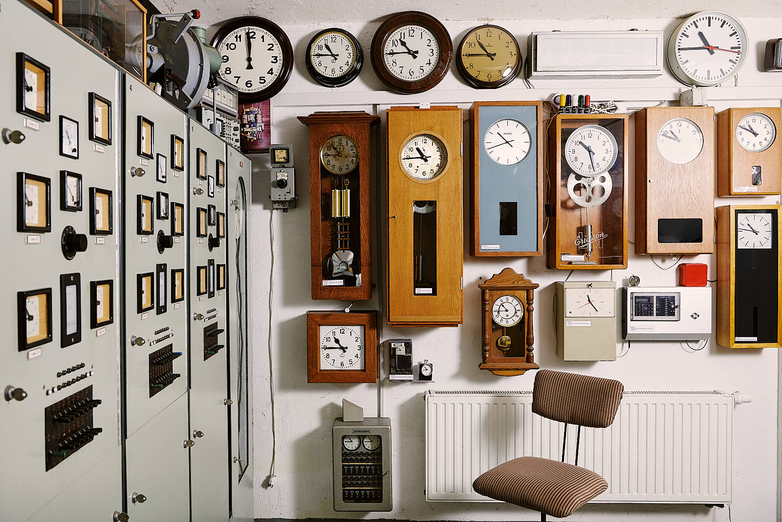 Clock 桌布 壁紙 — 一面牆密集地覆蓋著各種風格和尺寸的復古時鐘，位於一個復古工業風格的房間內。