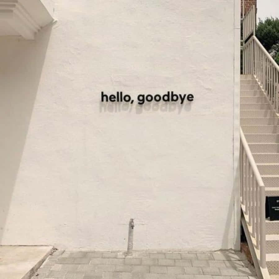 再見 桌布 壁紙 — 一面簡約白牆，上面有「hello goodbye」字樣，在明亮日光下於混凝土樓梯旁投下柔和陰影。