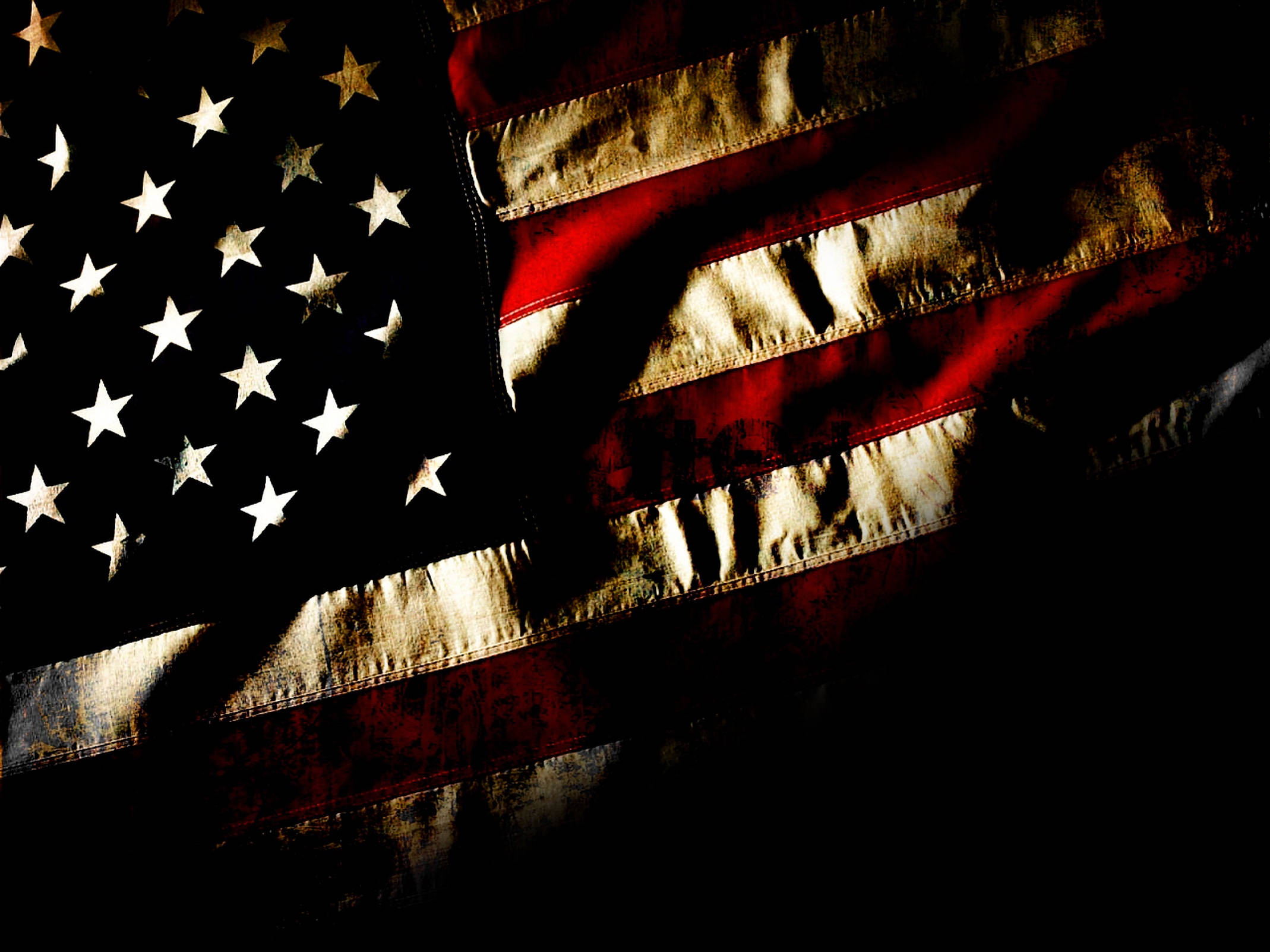 Black American Flag 桌布 壁紙 — 一面風化嘅美國國旗，帶有發光嘅星星同條紋，斜掛喺深色背景上。