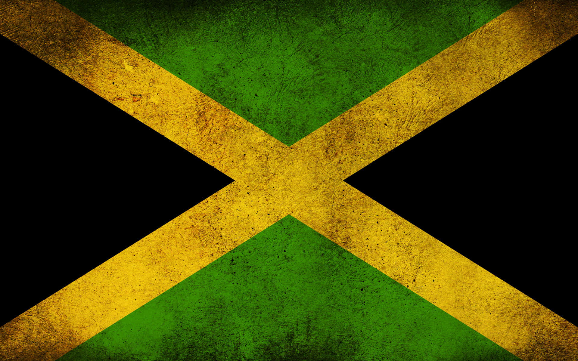 Jamaica 桌布 壁紙 — 一面飽經風霜的牙買加國旗，帶有鮮明的綠色、黃色和黑色，呈現粗糙的紋理表面。