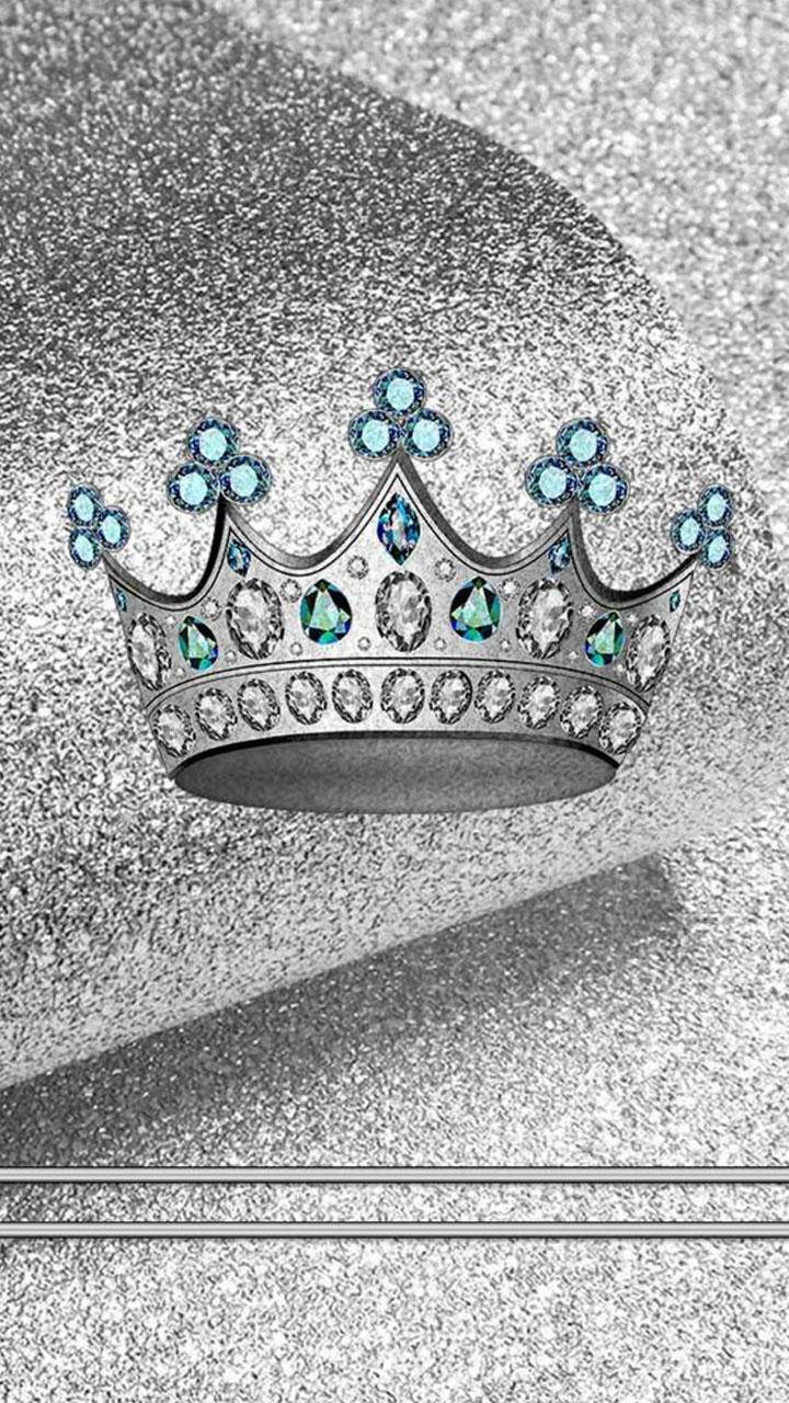 King And Queen 桌布 壁紙 — 一頂閃閃發光的銀色皇冠，飾有藍色和透明寶石，放置在帶有紋理的銀色表面上。