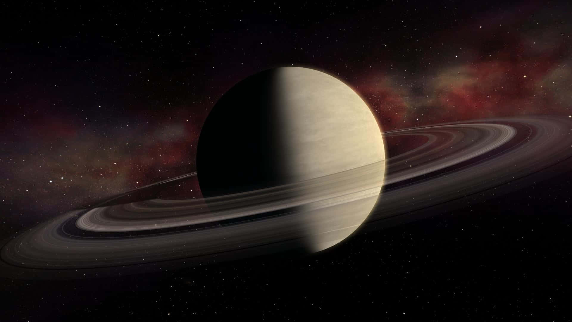 土星 桌布 壁紙 — 一顆宏偉的環狀行星在星光點點的星雲背景下，伴隨著旋轉的紅色和紫色雲霧，在半明半暗中發光。