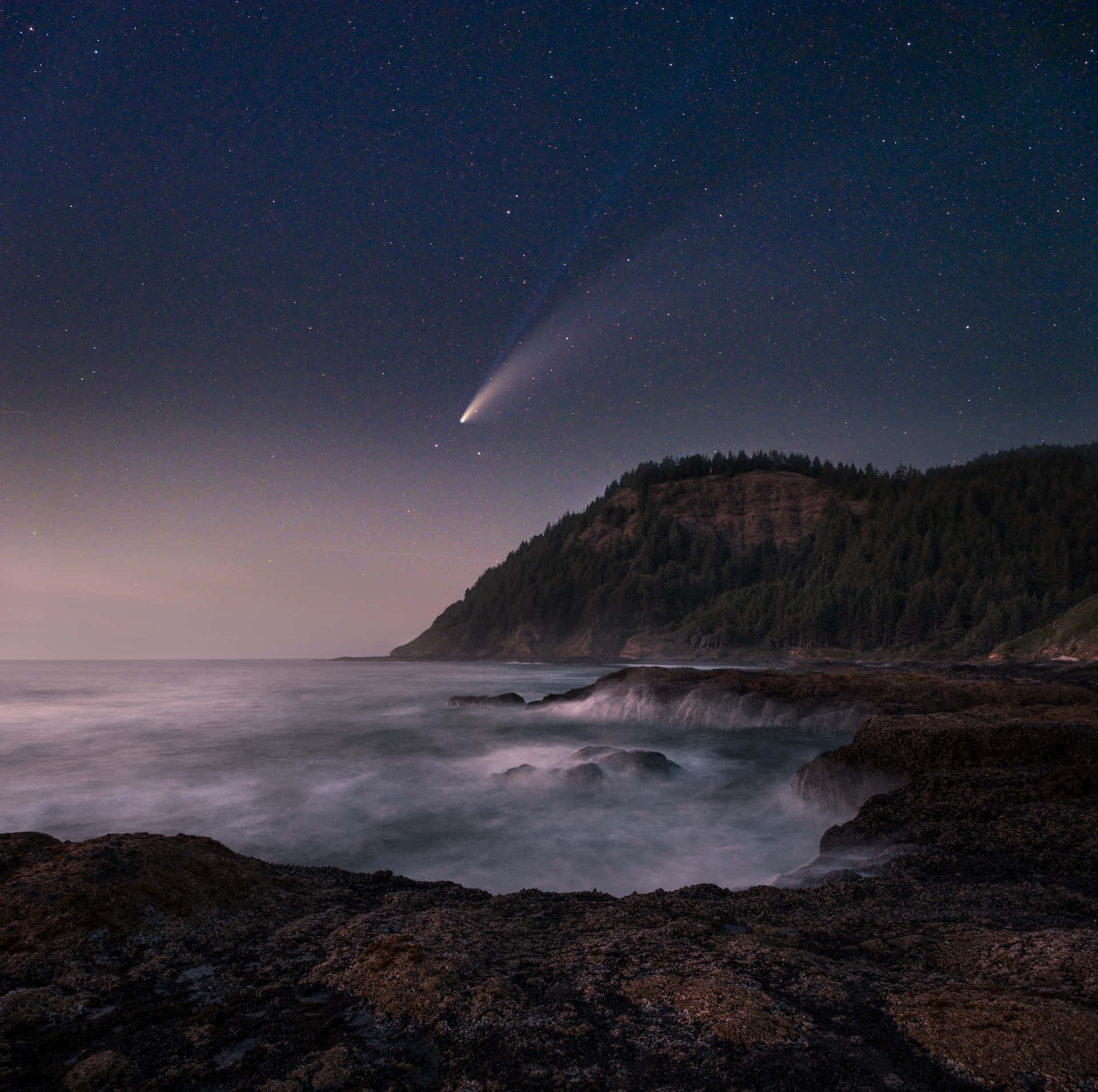 comet 桌布 壁紙 — 一顆彗星劃過繁星點點的夜空，下方是霧氣瀰漫的海岸懸崖，波濤拍岸。