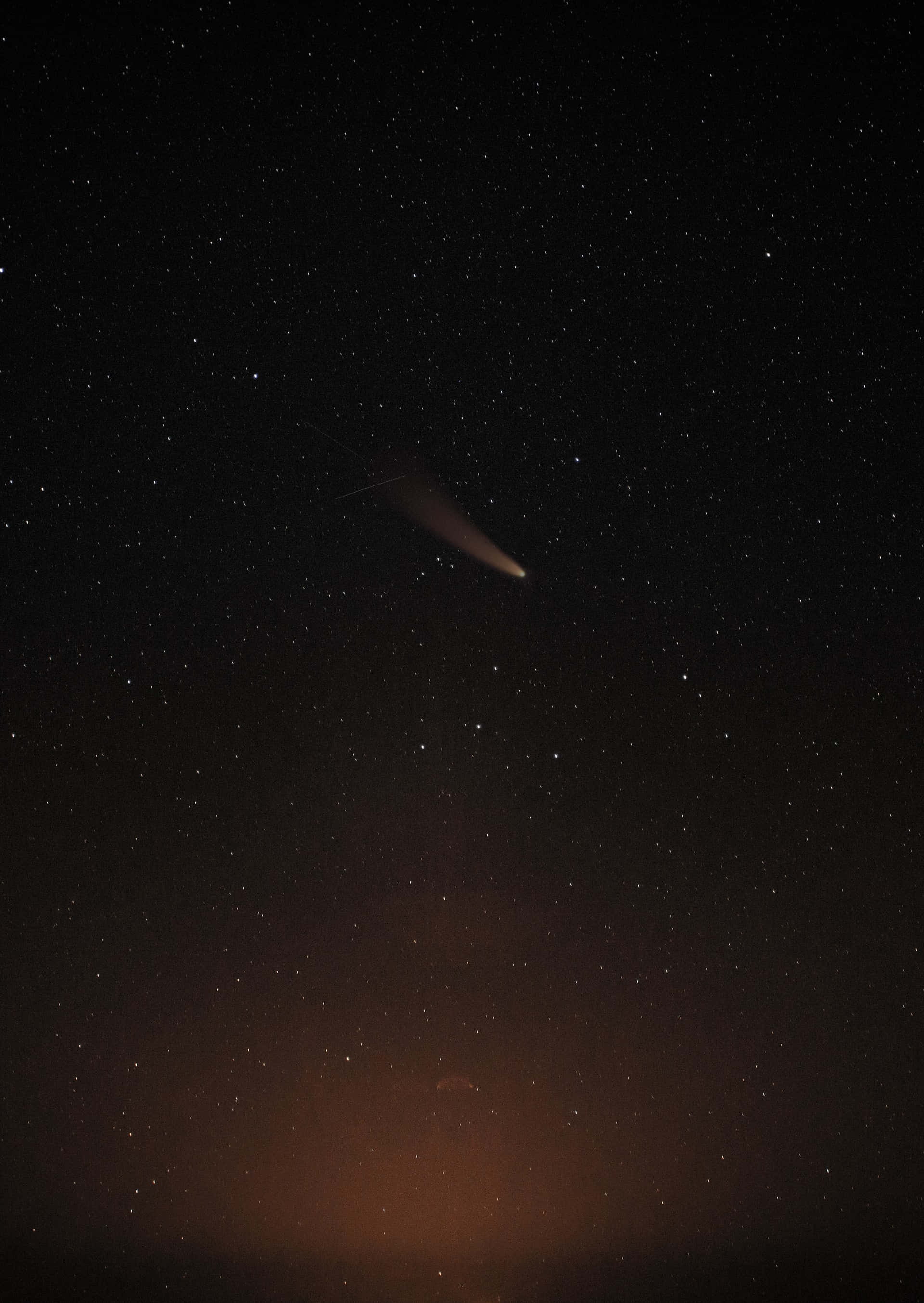 comet 桌布 壁紙 — 一顆明亮的彗星劃過繁星點點的夜空，帶有發光的尾巴和下方微弱的橙色極光。