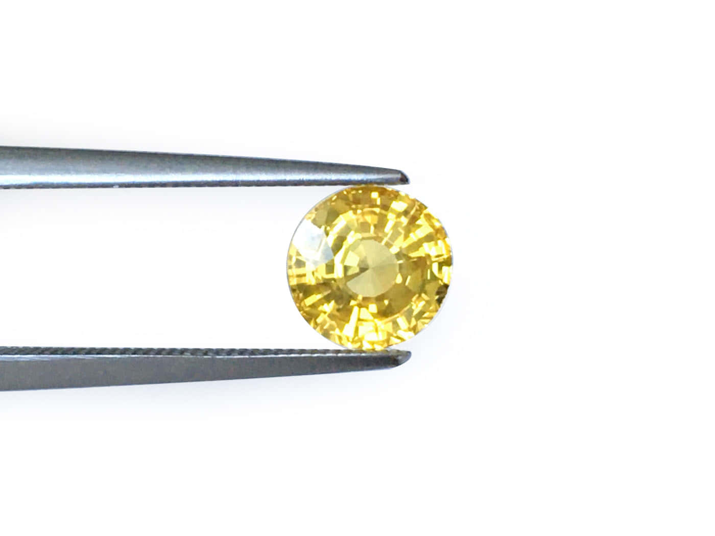Yellow Sapphire 桌布 壁紙 — 一顆璀璨的黃色圓形切割寶石，被精密鑷子輕柔夾住，置於純白背景前。