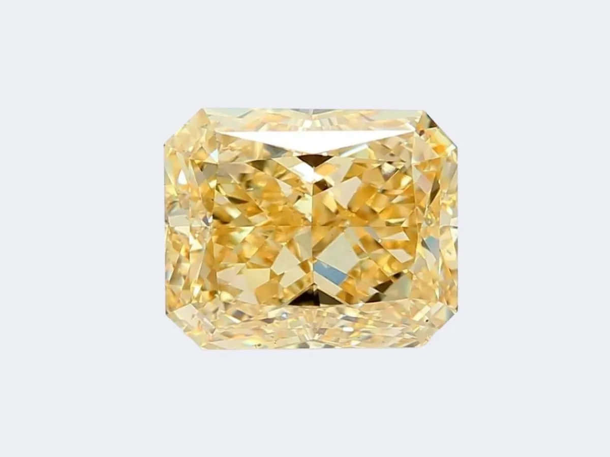 Yellow Diamond 桌布 壁紙 — 一顆璀璨的黃色枕形切割鑽石，在柔和的灰色背景上閃耀著複雜的切面。