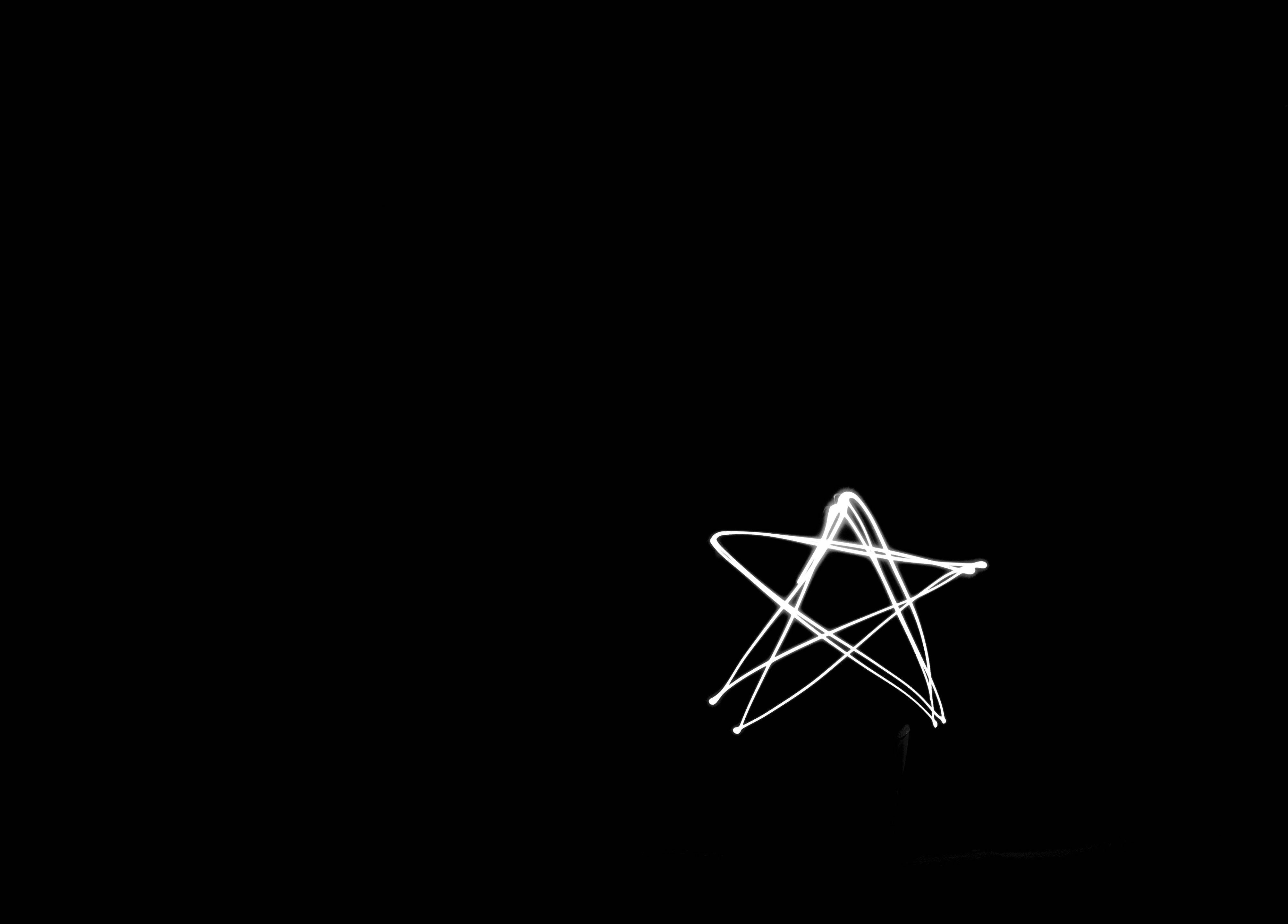 黑色動態圖 桌布 壁紙 — 一顆發光的白色星星，在純黑色背景上以光跡繪製而成。