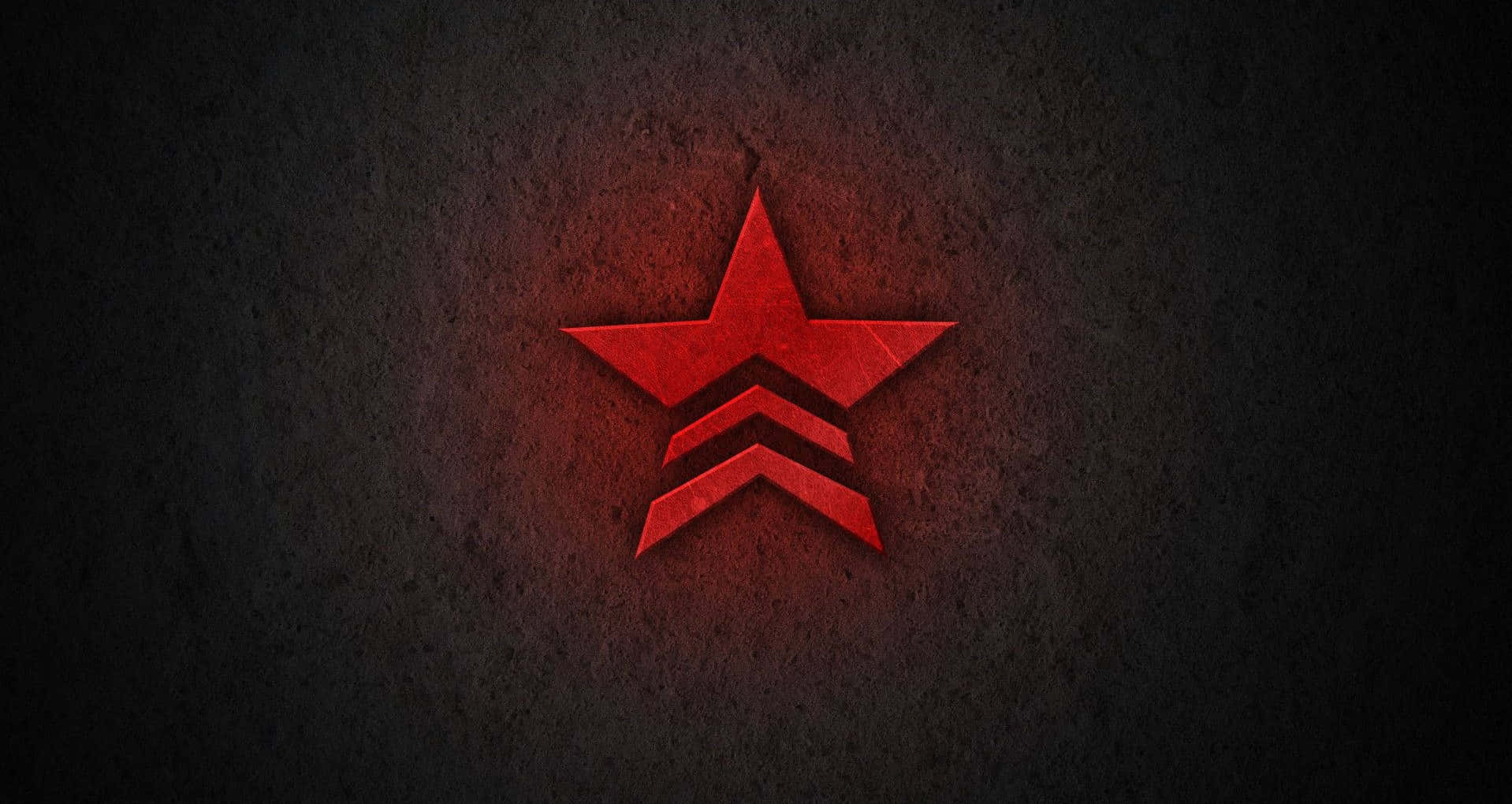 Red Star 桌布 壁紙 — 一顆發光的紅星，下方有三個V形標誌，在粗糙的暗牆上投射出溫暖的光芒。
