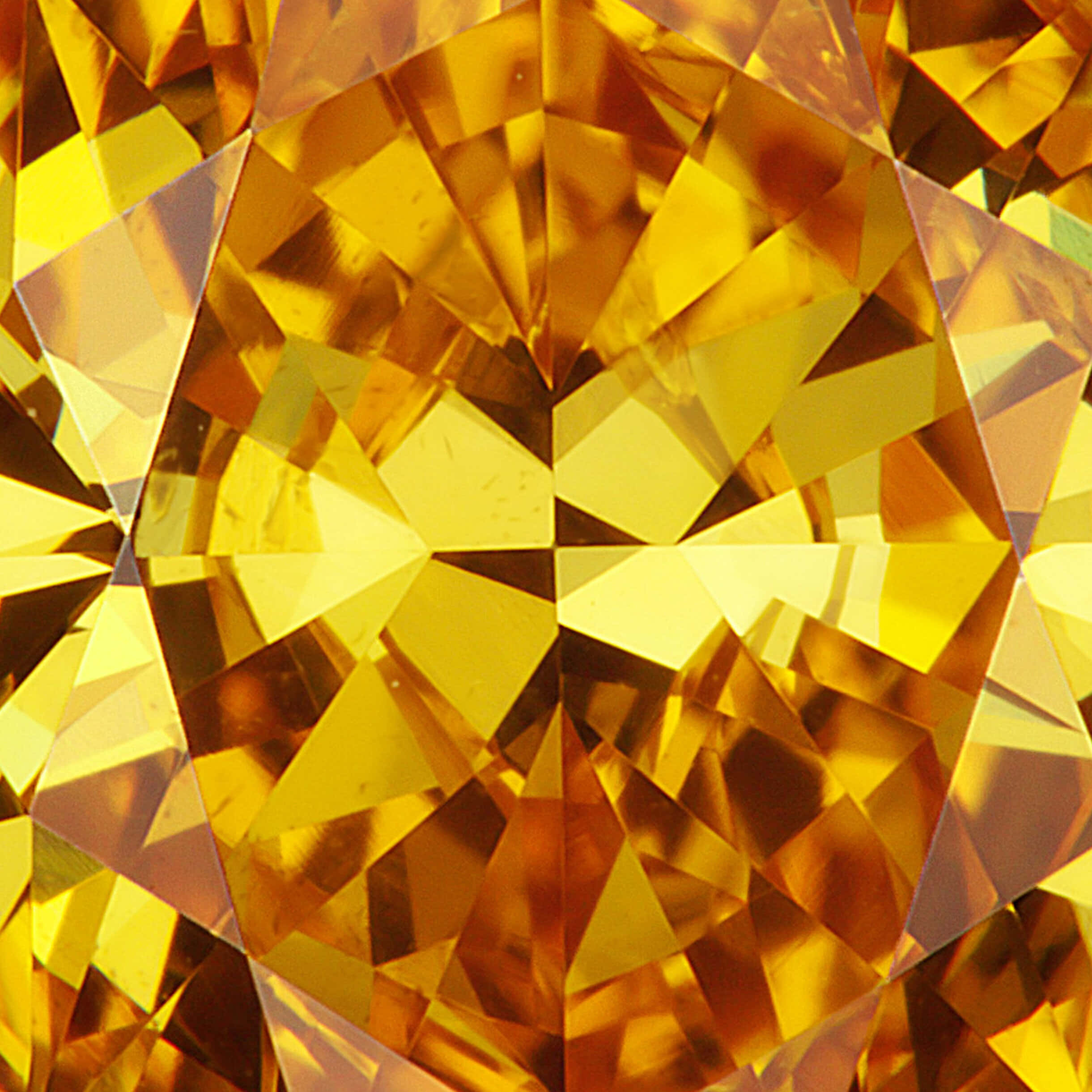 diamonds 桌布 壁紙 — 一顆經過幾何切割的黃金黃色寶石的特寫，散發出溫暖的光芒。