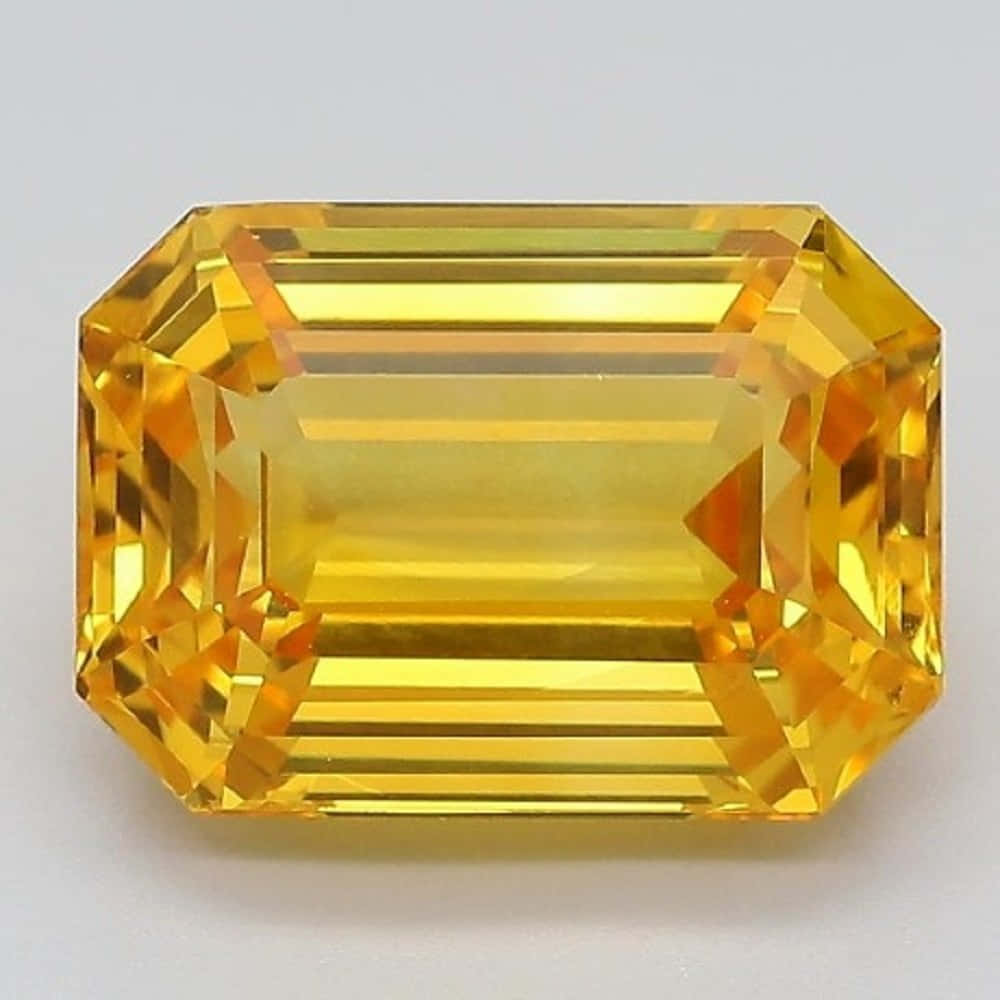 Yellow Sapphire 桌布 壁紙 — 一顆閃耀的祖母綠切割黃色寶石，在中性背景上以精確的刻面閃爍光芒。