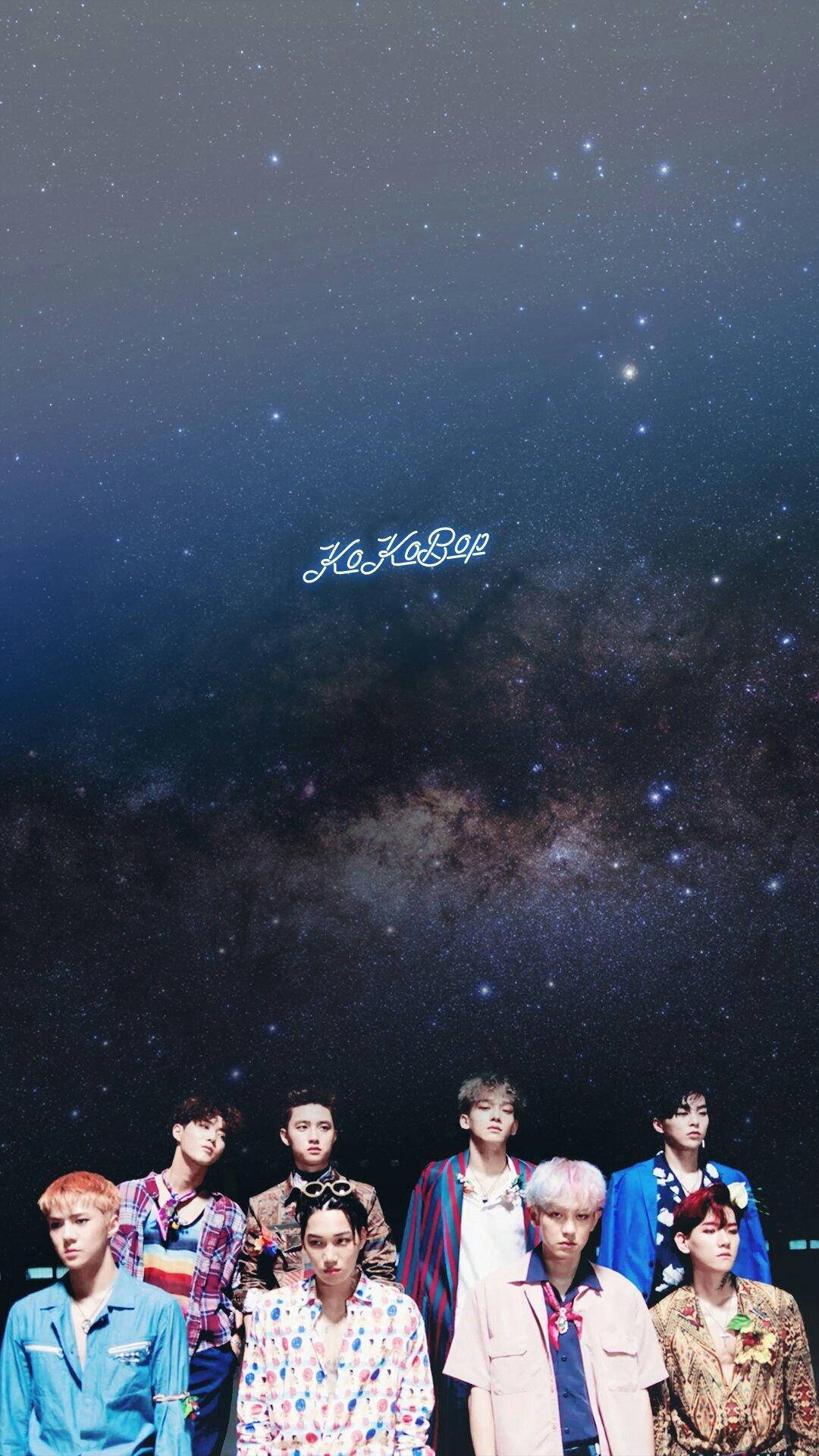 七位穿著色彩繽紛服裝的K-pop偶像站在星空和銀河下。