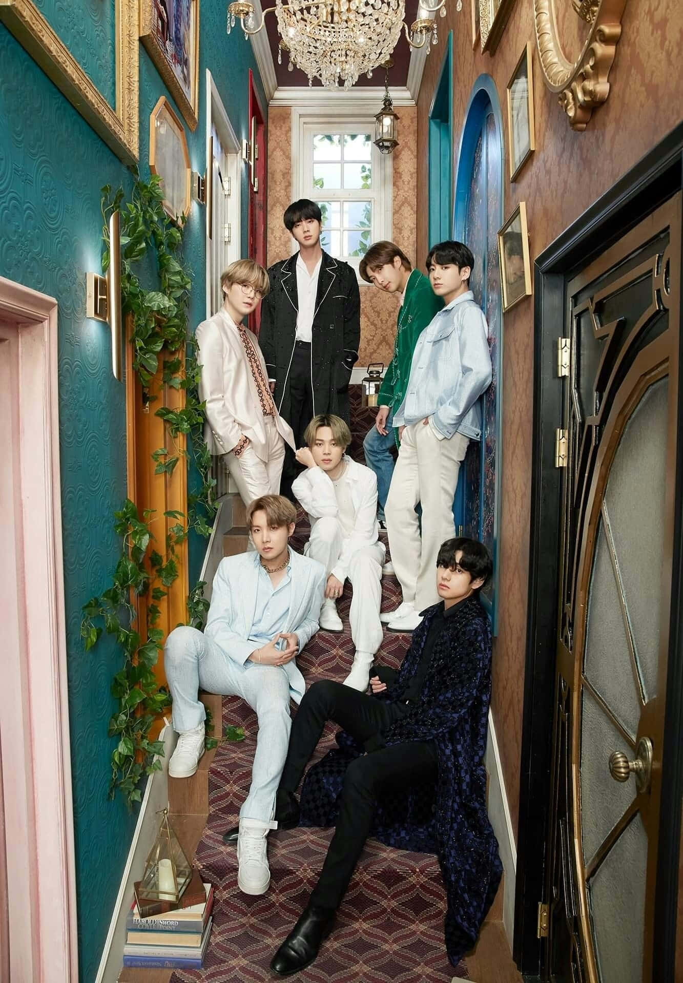 Big Hit Entertainment 桌布 壁紙 — 七位時尚男士在一個宏偉華麗的走廊中擺姿勢，走廊有青綠色牆壁、金色飾邊和頭頂的水晶吊燈。