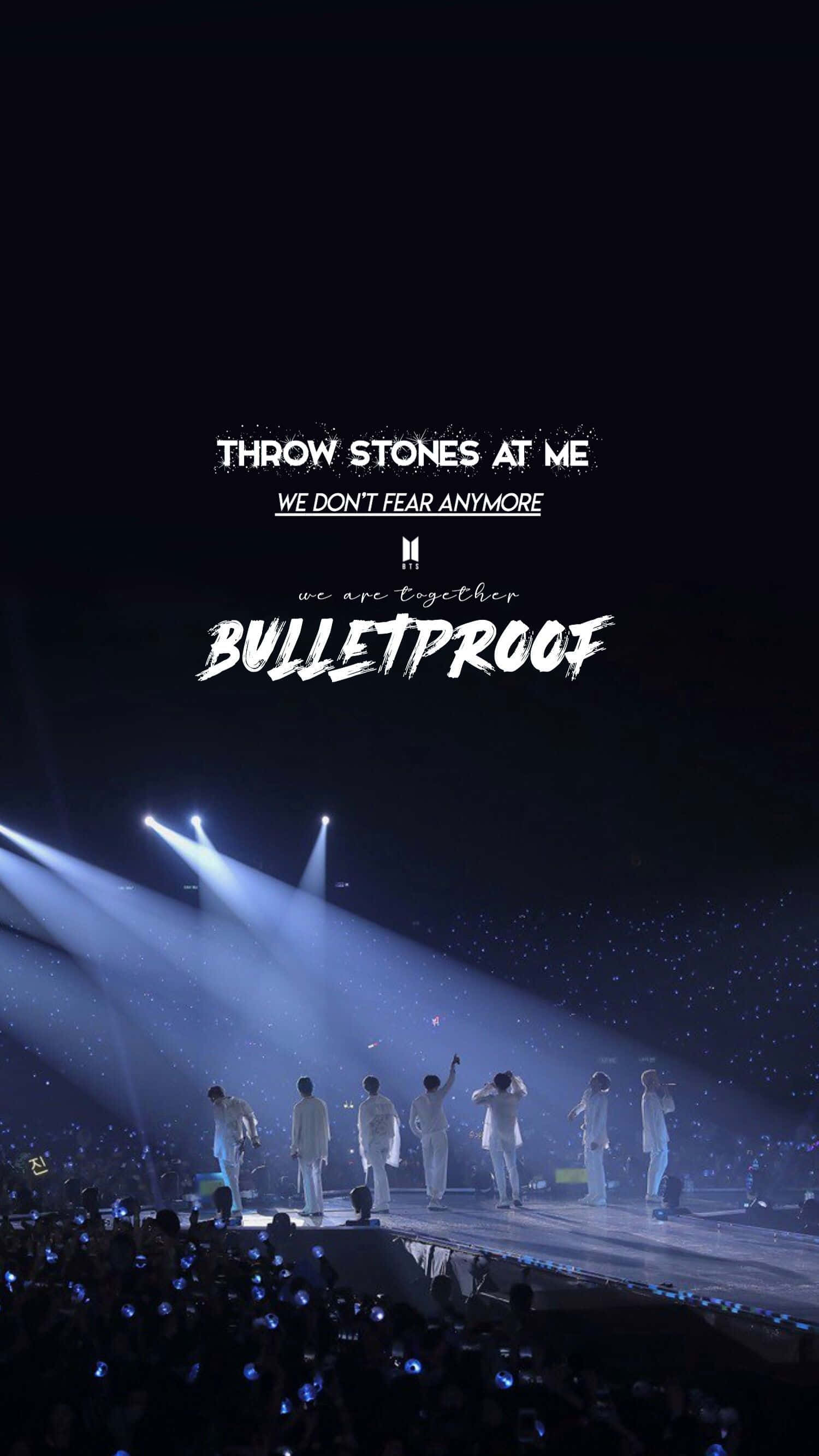 Bts Performance 桌布 壁紙 — 七位身穿白色服裝的表演者站在燈光明亮的舞台上，聚光燈下，黑暗的觀眾在下方手持發光的藍色燈光。