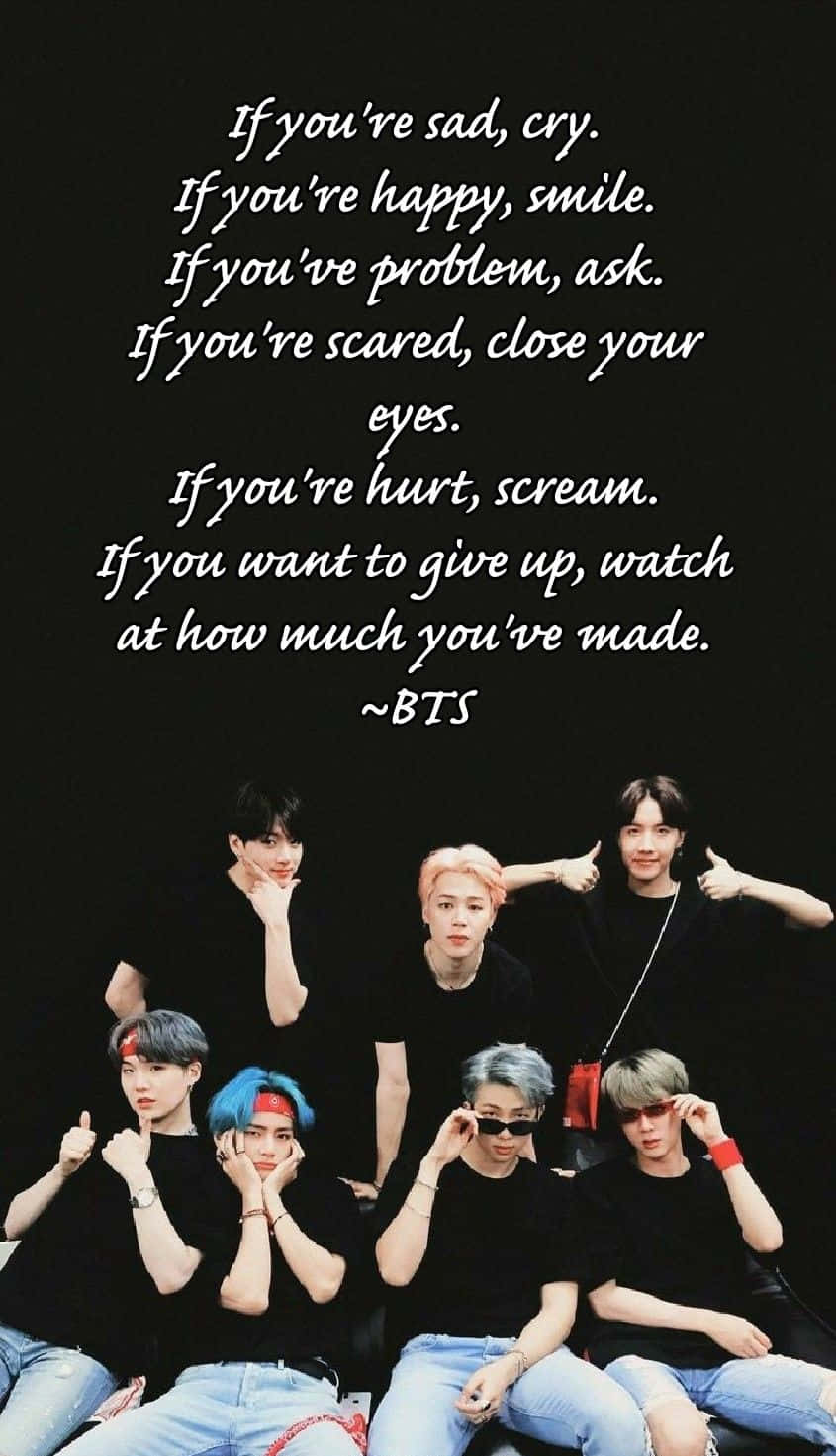 Bts Inspirational 桌布 壁紙 — 七位身穿黑色上衣和牛仔褲的年輕男性在黑色背景前擺姿勢，並疊加白色勵志文字。