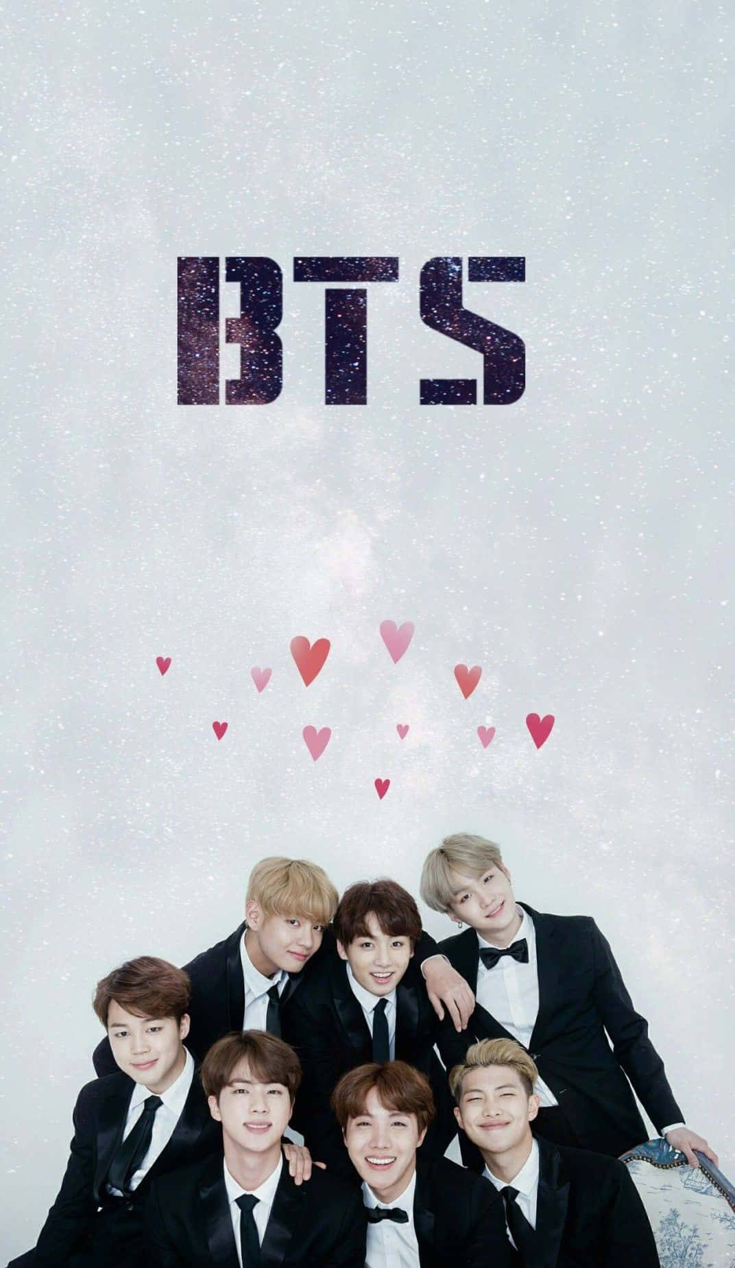 Bangtan Sonyeondan 桌布 壁紙 — 七個微笑嘅男人著住黑色禮服，喺閃爍嘅BTS標誌同漂浮嘅粉紅色心形下面，喺雪景背景下擺姿勢。