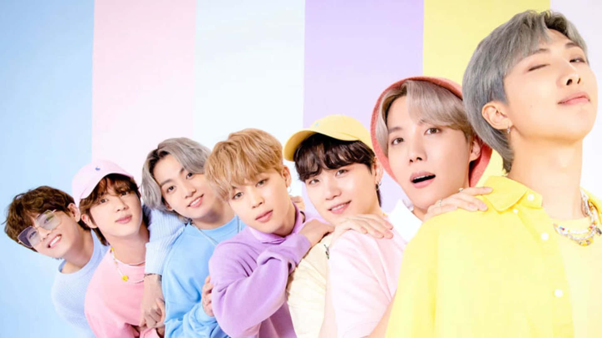 BTS - BTS - BTS - BTS - BTS - B 壁紙 — 七名身穿柔和色調服裝的年輕男性，在充滿活力的條紋背景前緊密擺姿勢，面帶愉快表情。