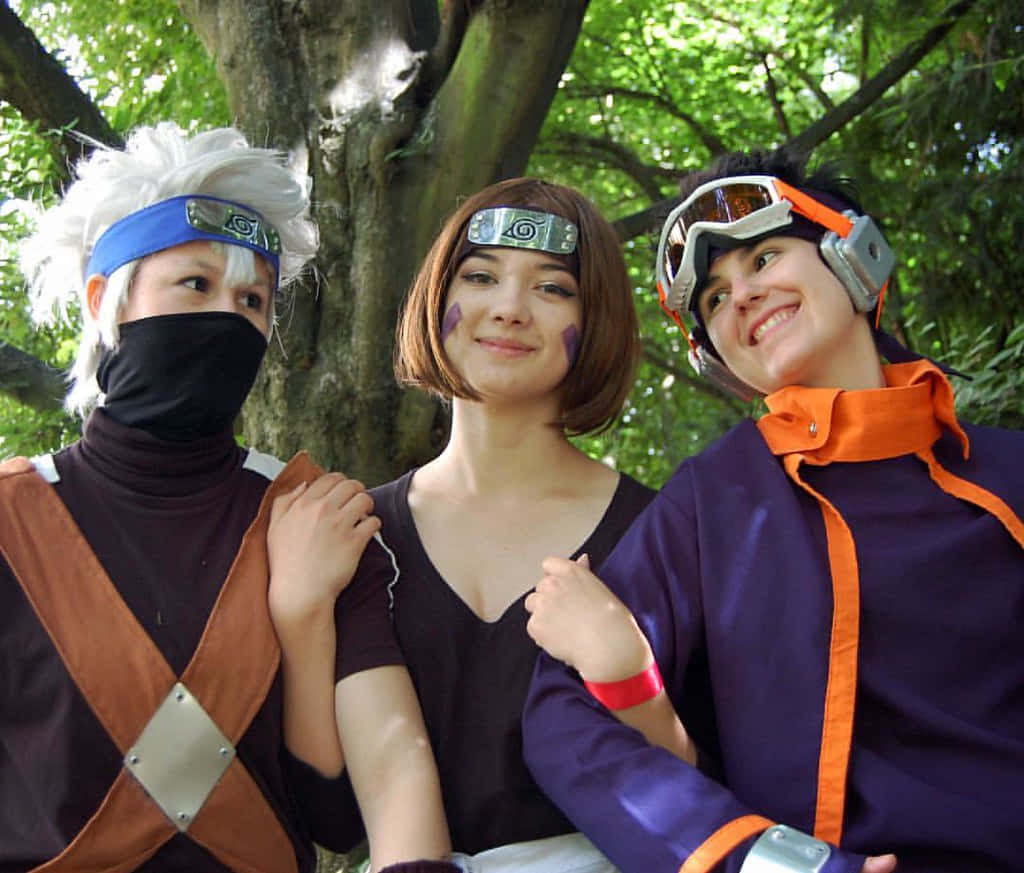 Kakashi And Rin 桌布 壁紙 — 三位動漫角色扮演者穿著火影忍者服裝，在明亮的自然光下，於枝葉茂密的樹下愉快地擺姿勢。
