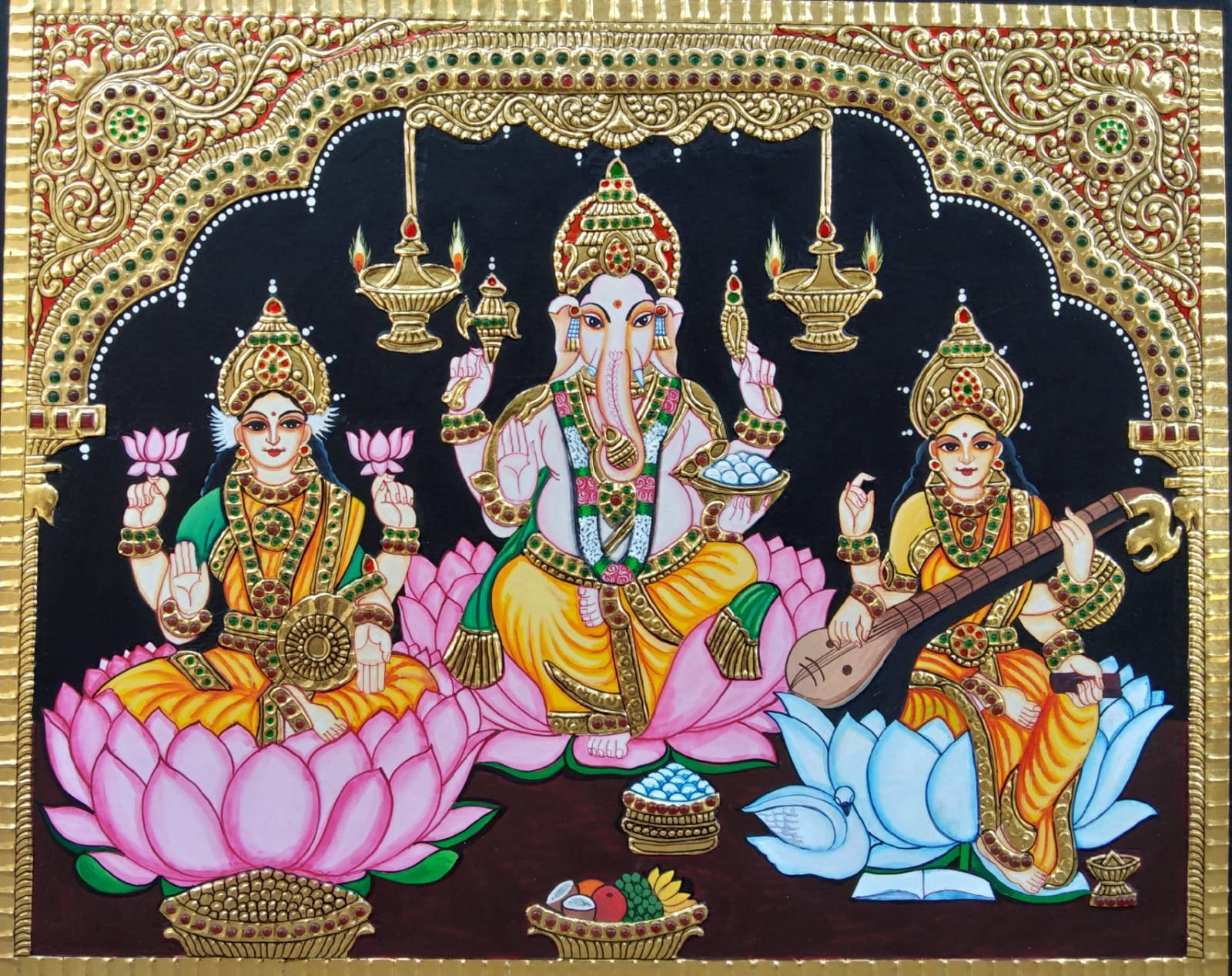 laxmi ganesh saraswati 桌布 壁紙 — 三位印度教神祇莊嚴地坐在粉紅色和藍色的蓮花上，上方是裝飾華麗的金色拱門，掛著吊燈。